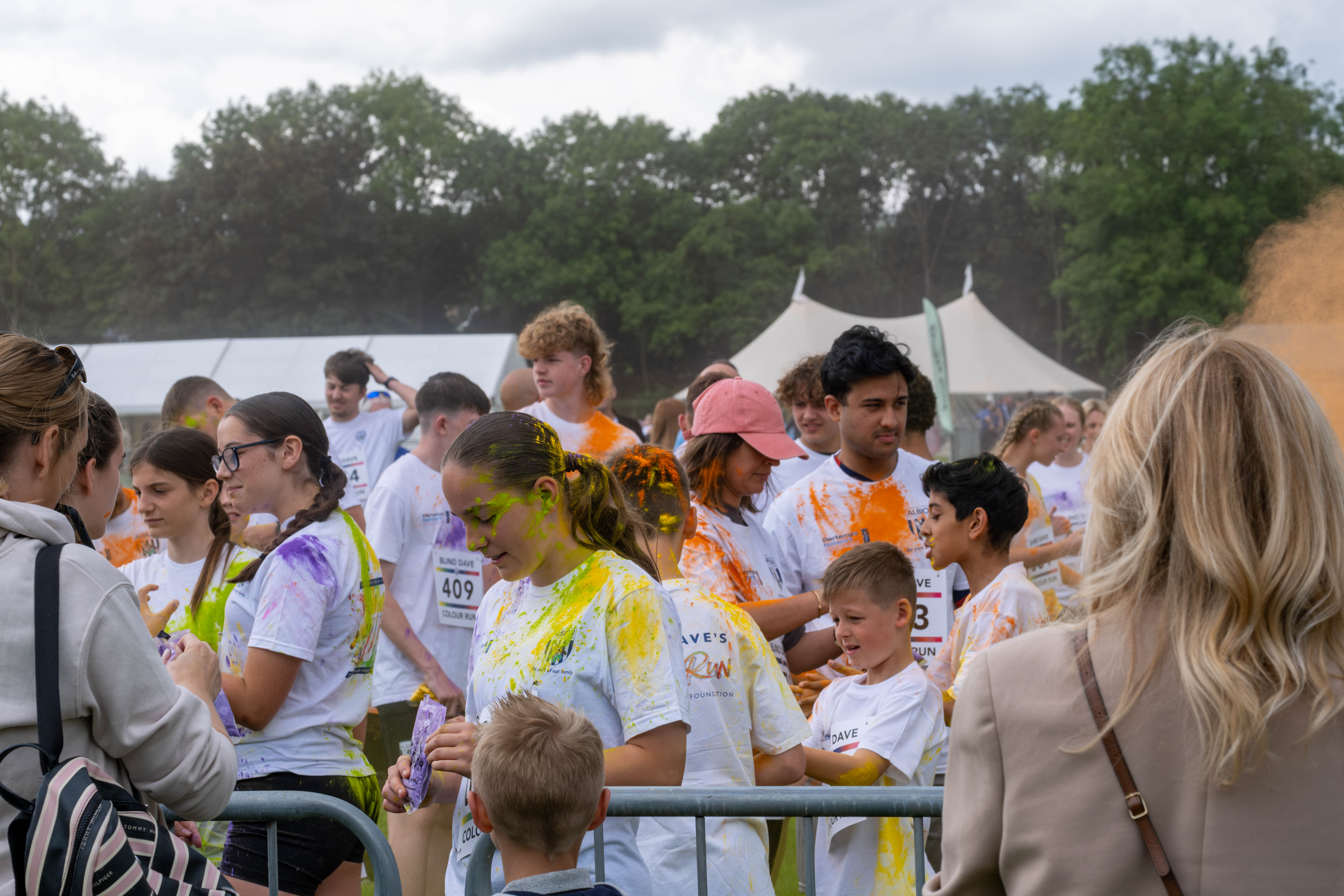 Group of participants inside barrier throwing paint powder.