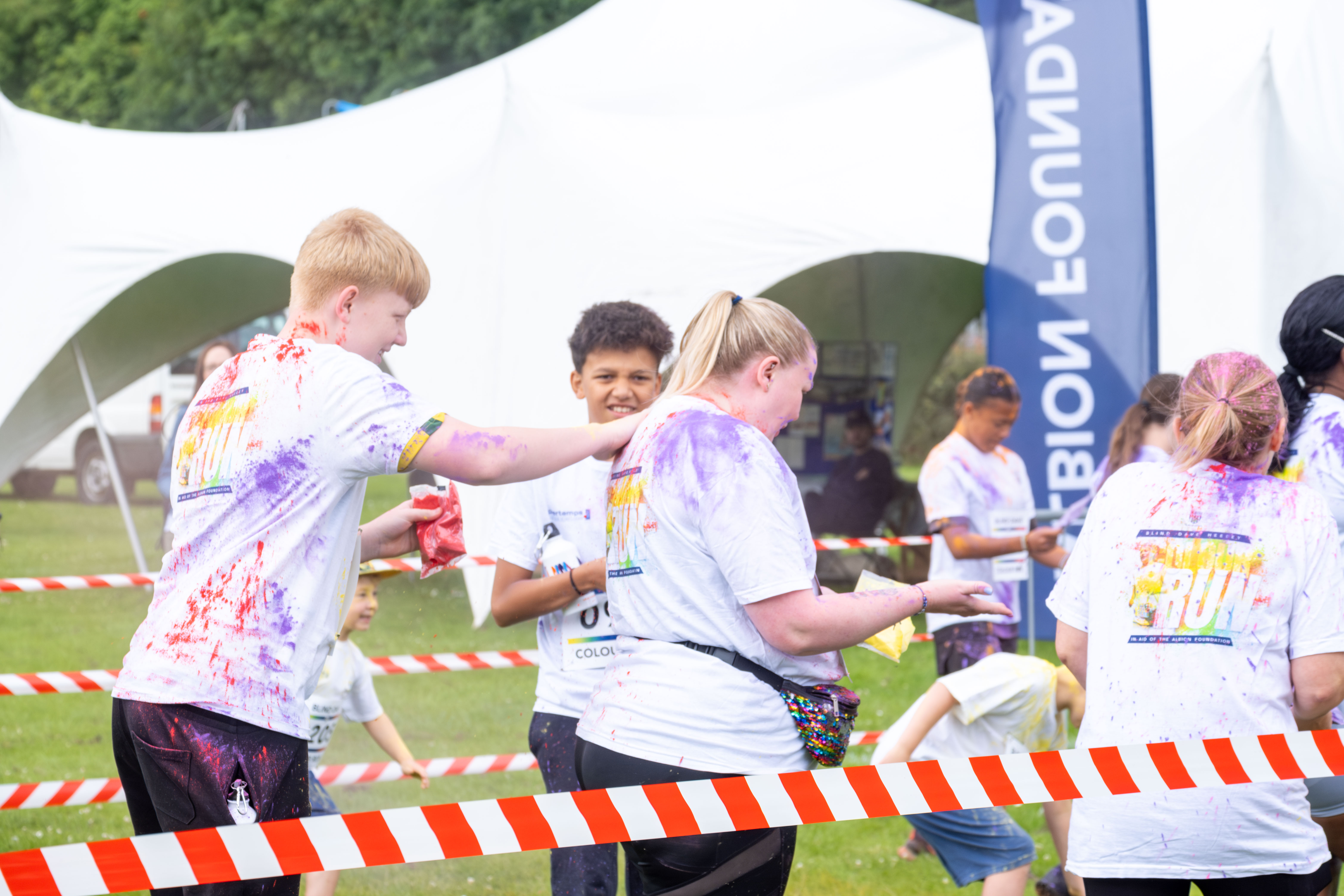 Group of participants inside barrier throwing paint powder.