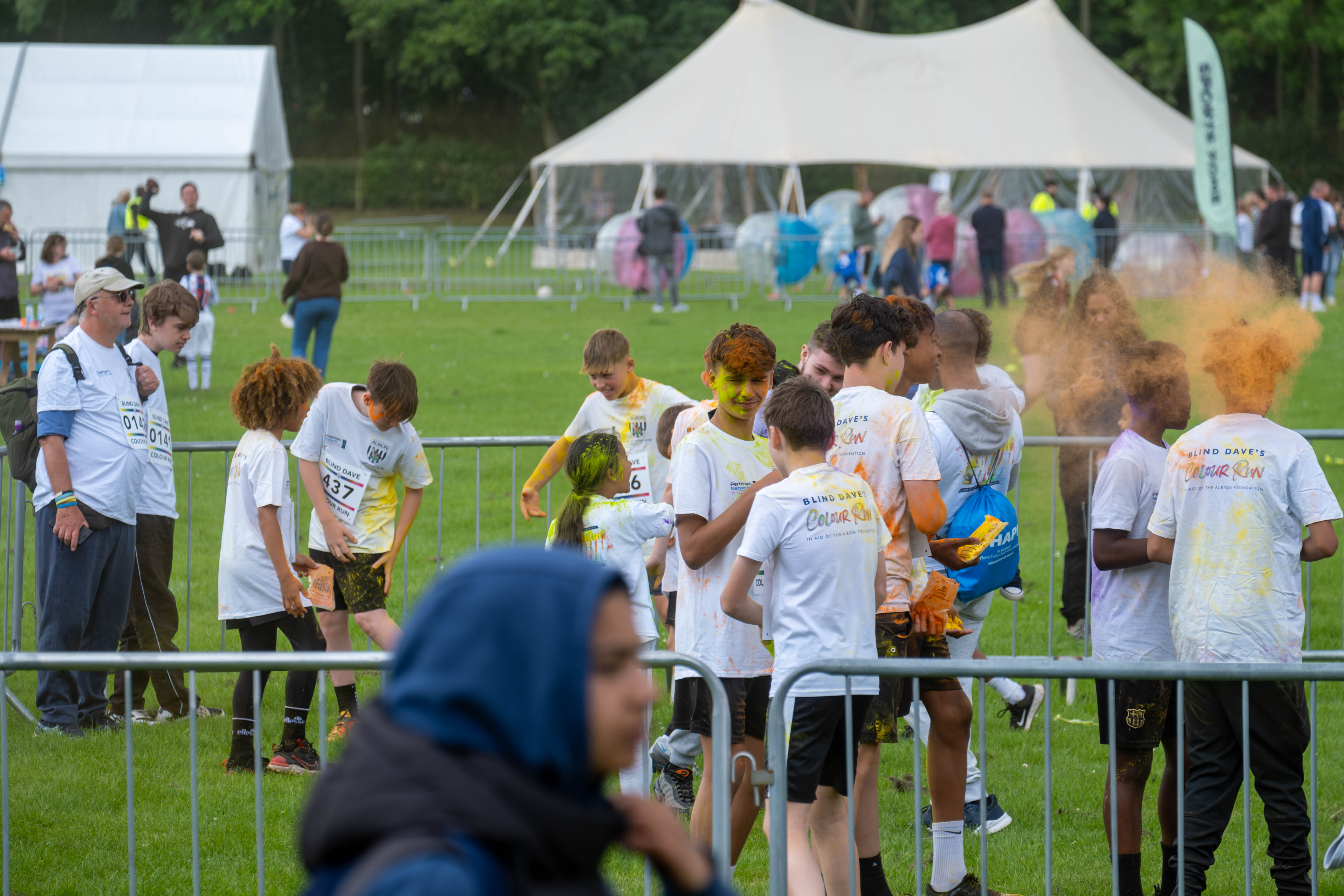 Group of participants inside barrier throwing paint powder.