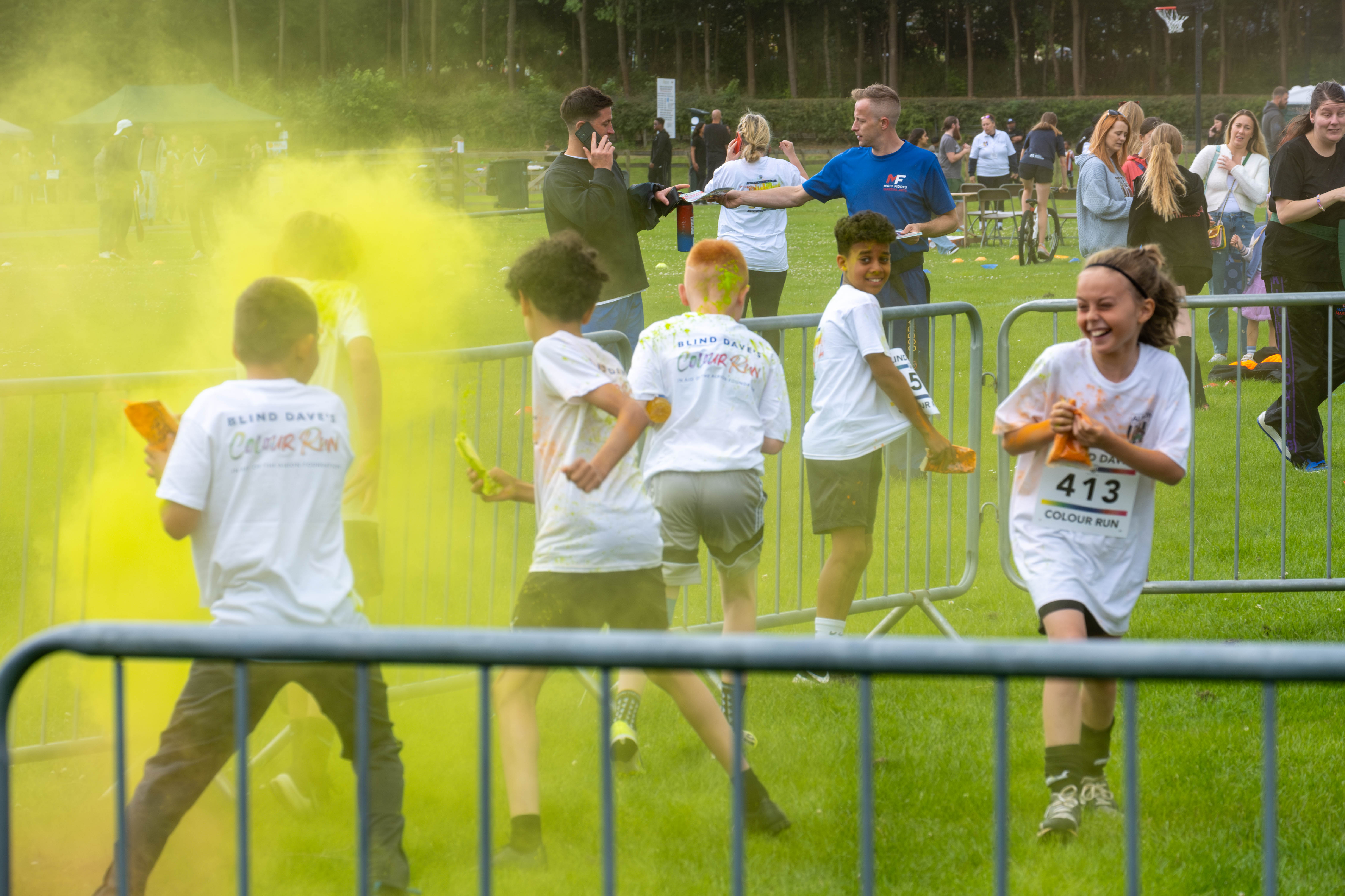 MJPL teammates throwing yellow paint powder.