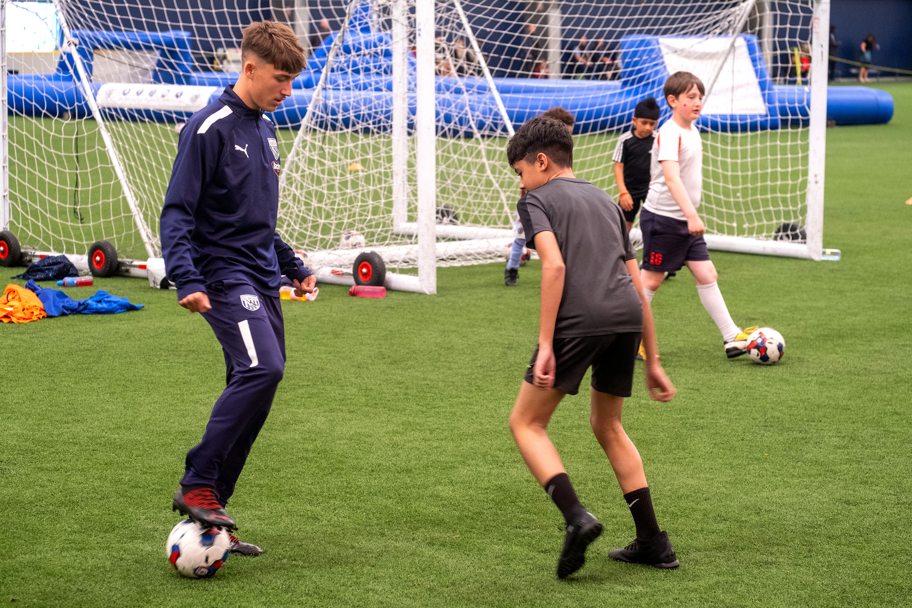 Reece with ball at his feet, with a participant attempting to intercept.