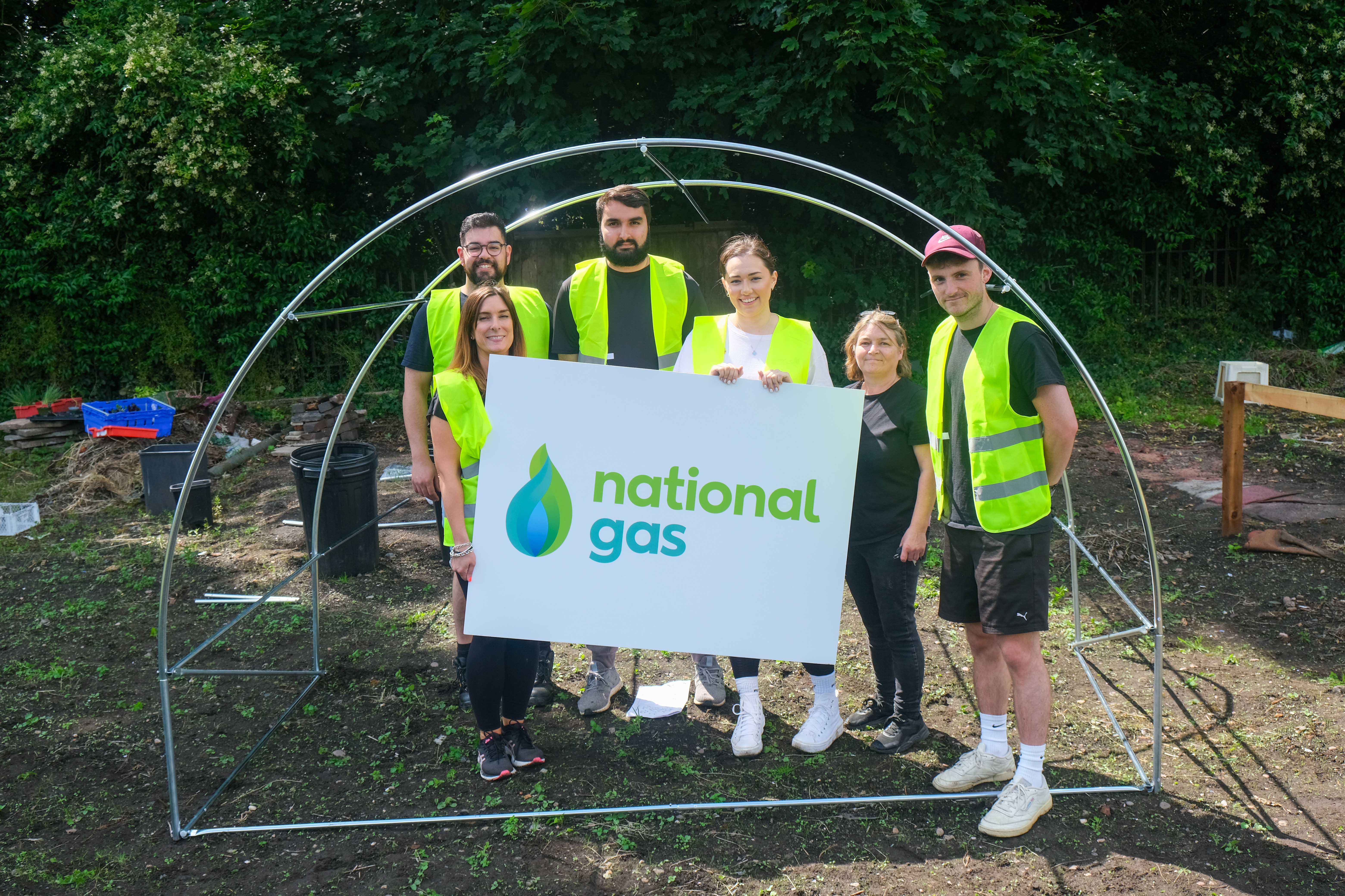 National Gas staff hold up their banner in-front of allotment infrastructure put up by staff.