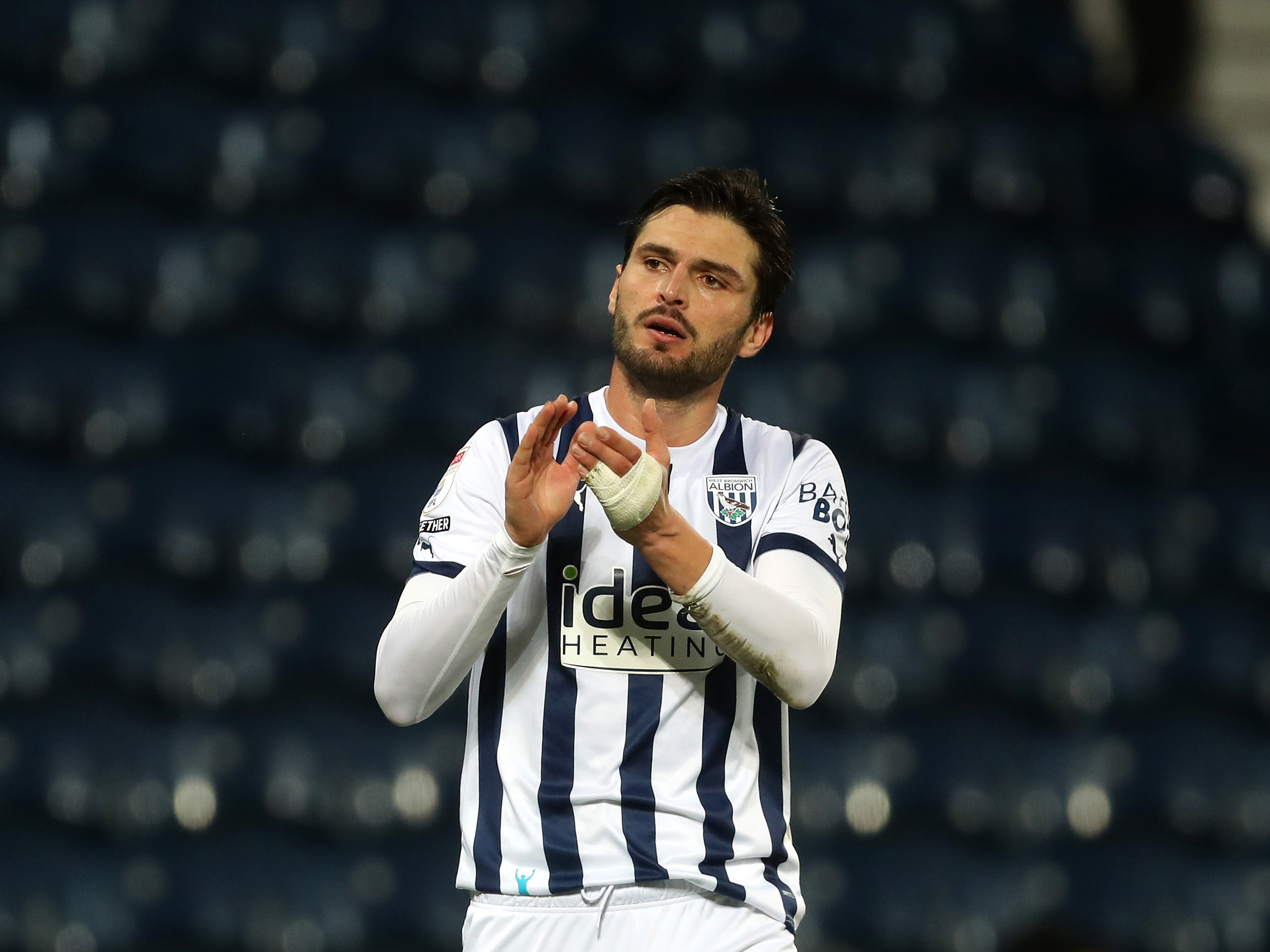 Okay Yokuslu applauding Albion fans wearing the home shirt 