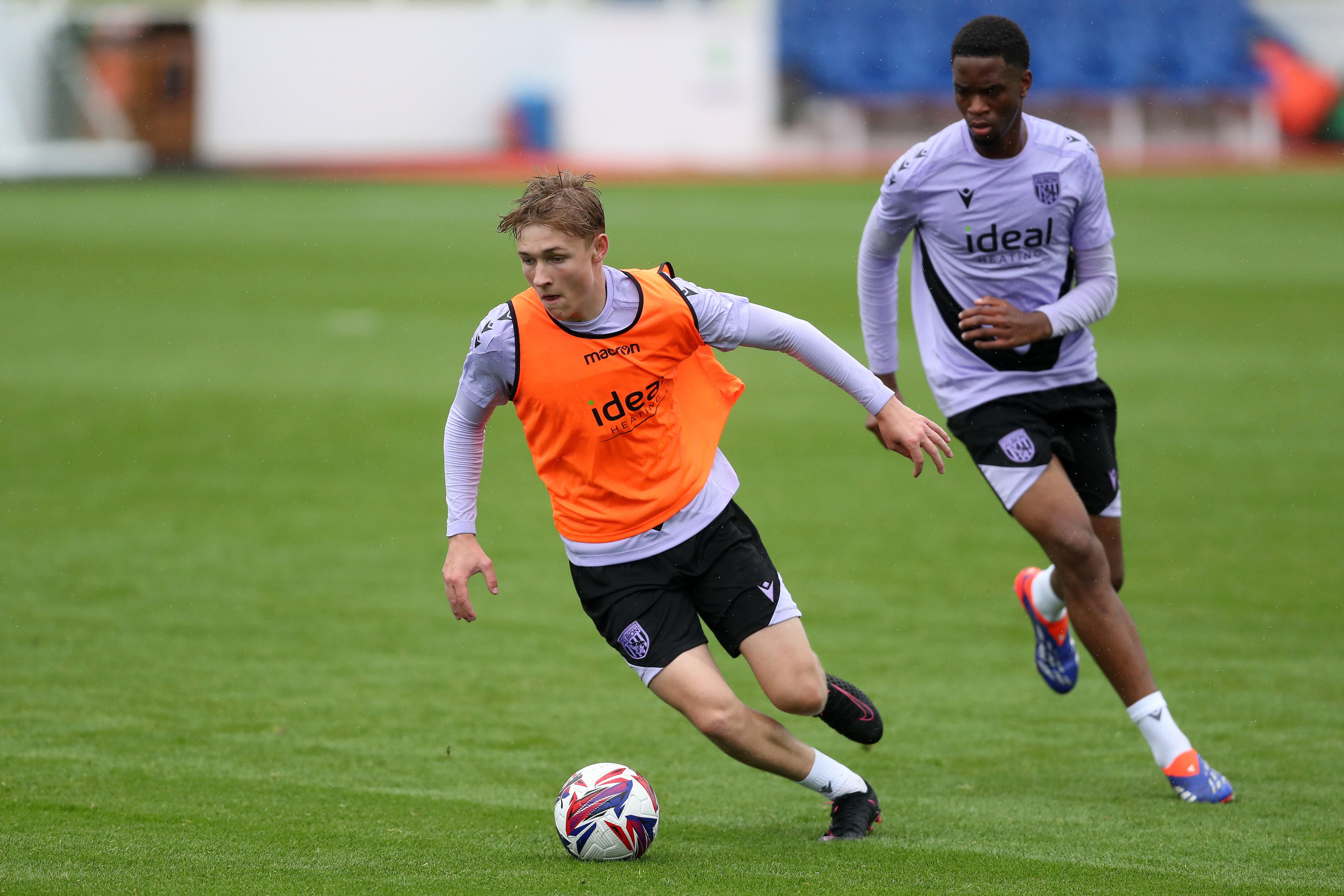 Ollie Bostock on the ball during training at St. George's Park wearing a bib