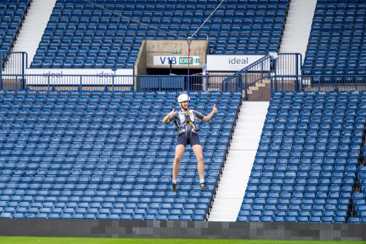 A participant puts his thumbs up as he heads across the Zipwire.