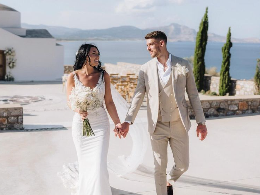 An image of Alex Palmer and his wife Penny holding hands on their wedding day