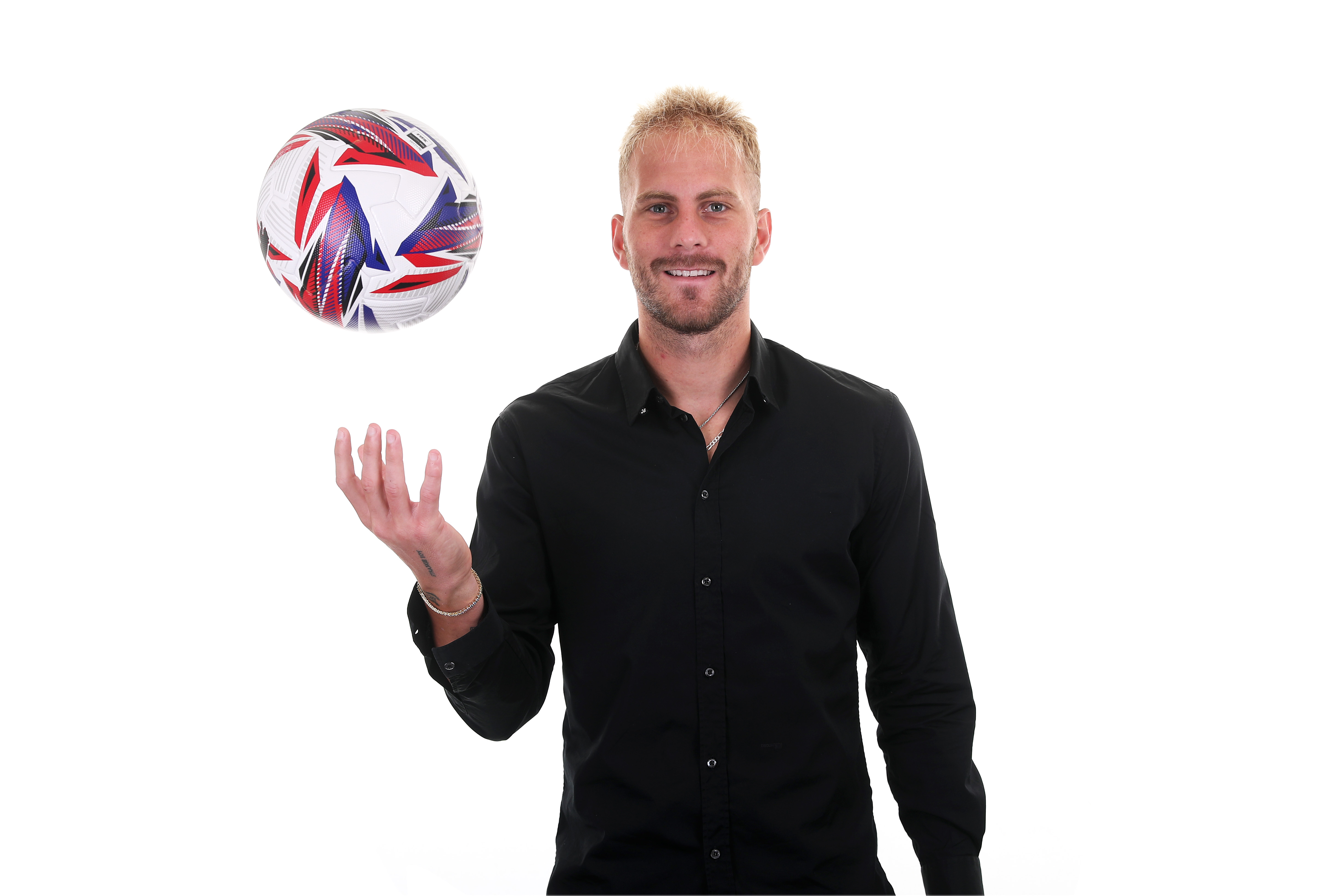 Uroš Račić smiling at the camera while juggling a ball 