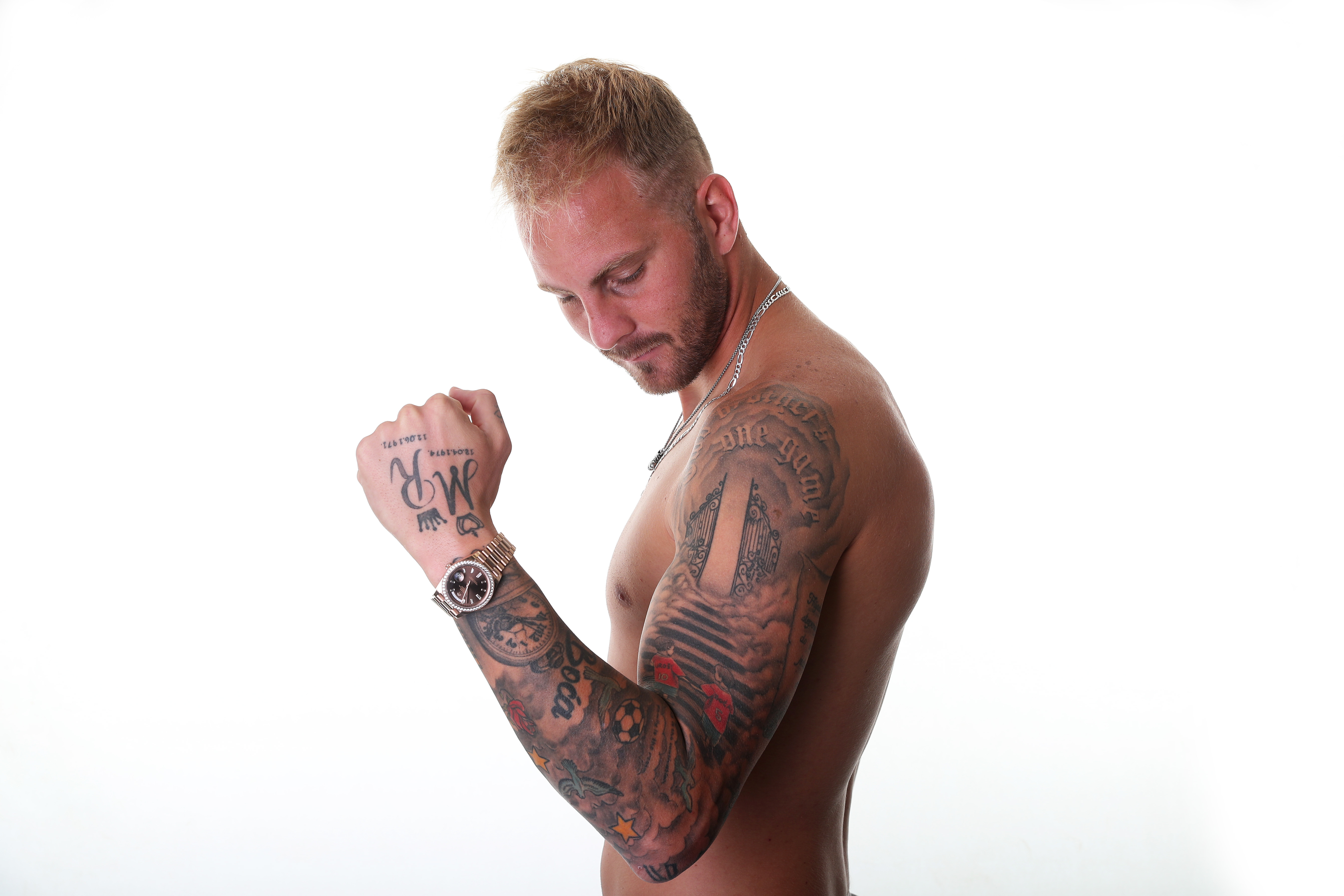 Uroš Račić posing for a photo showing off his tattoos on his arm 