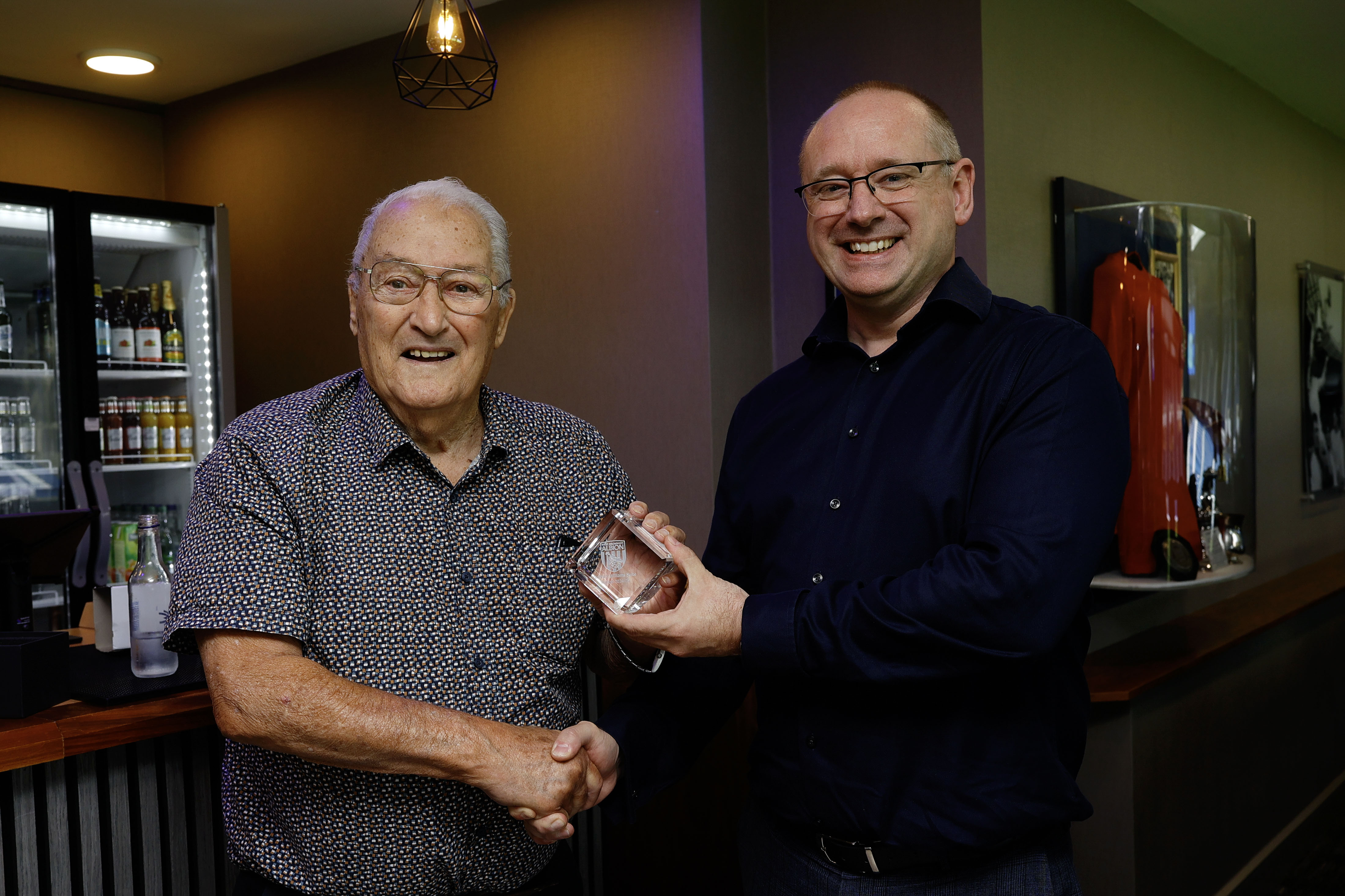 Graham Williams shaking hands with Mark Miles inside the Graham Williams Suite 