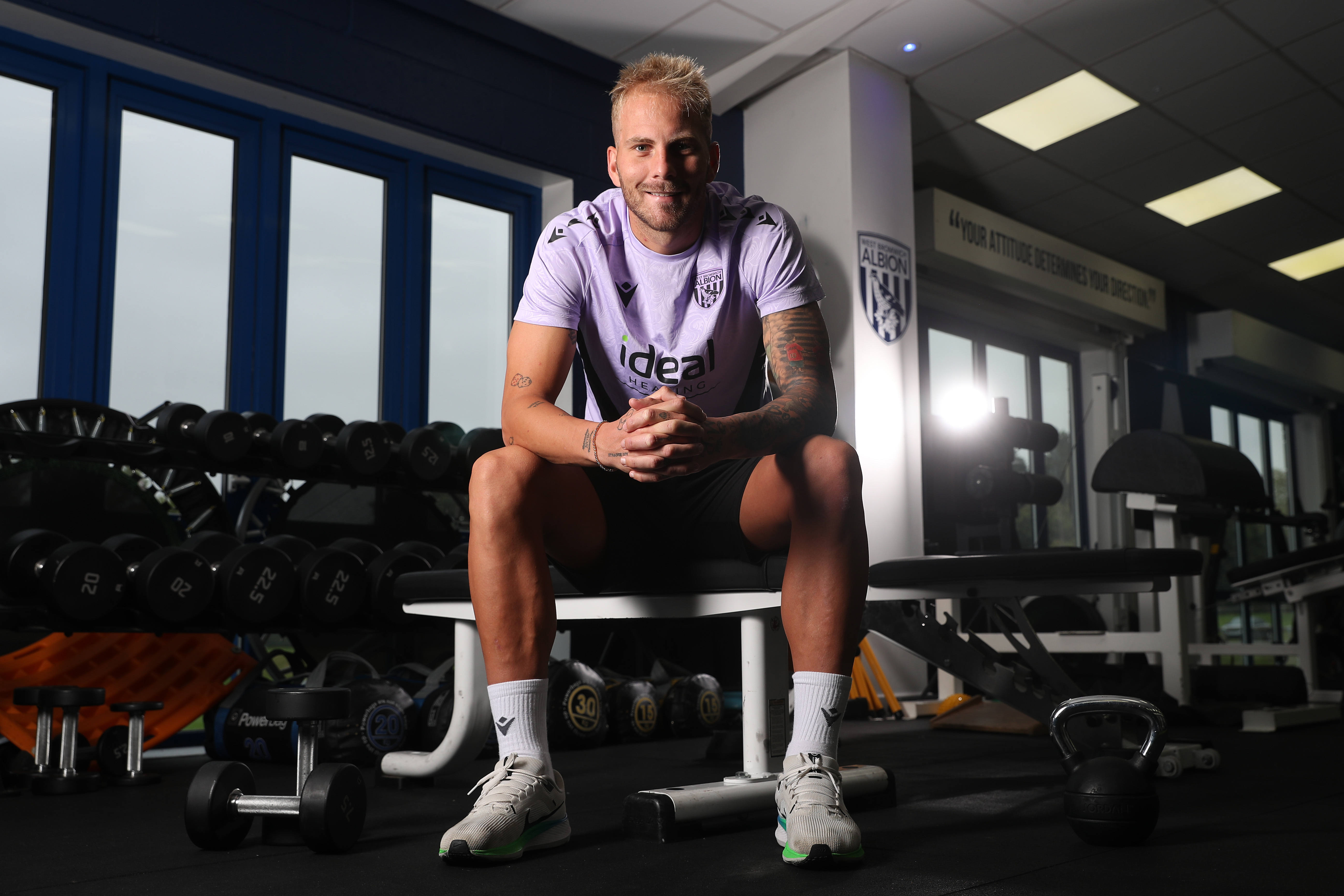 Uroš Račić smiling at the camera while sat in gym 