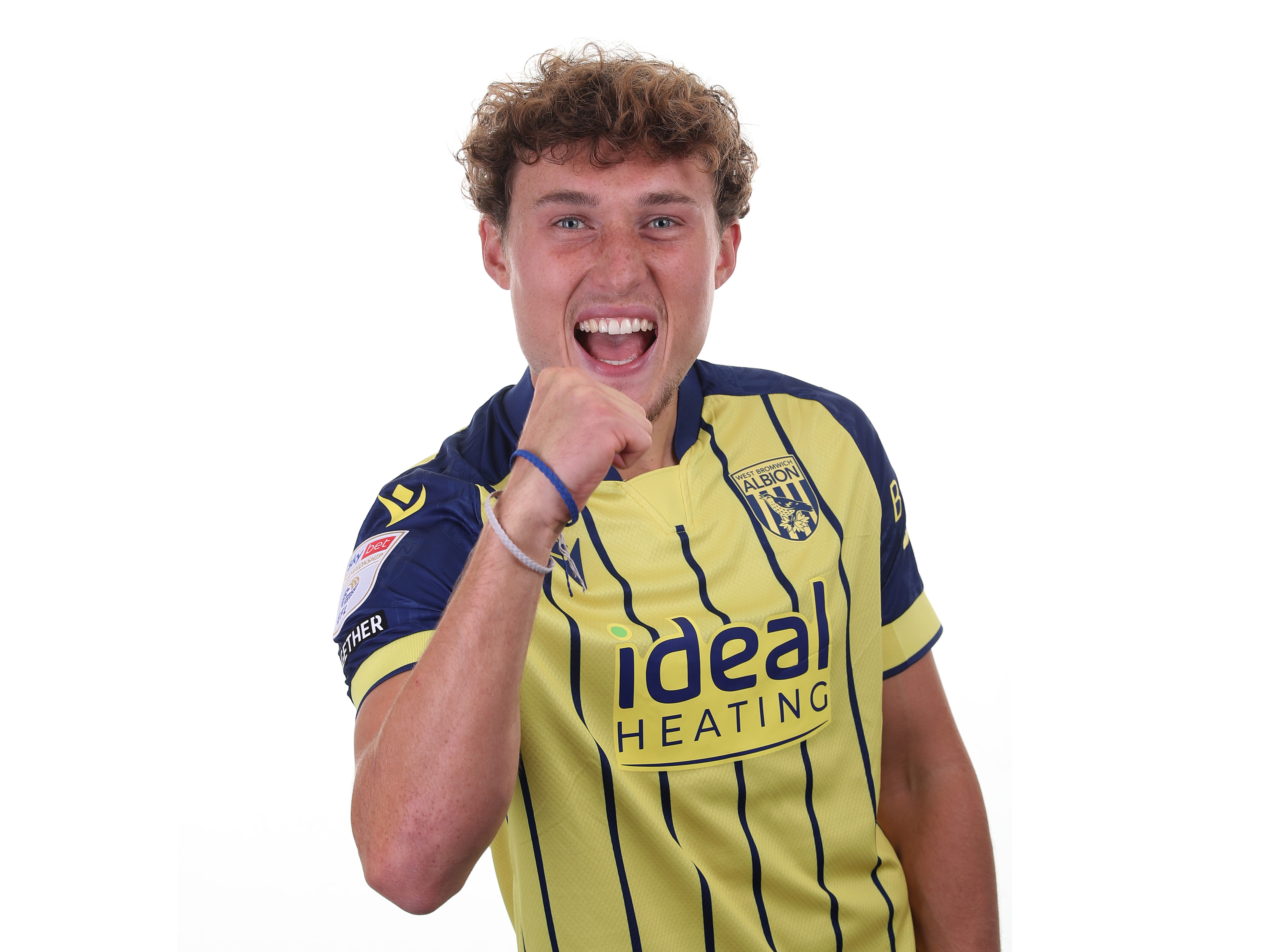 Callum Styles celebrating to the camera in the yellow away shirt 