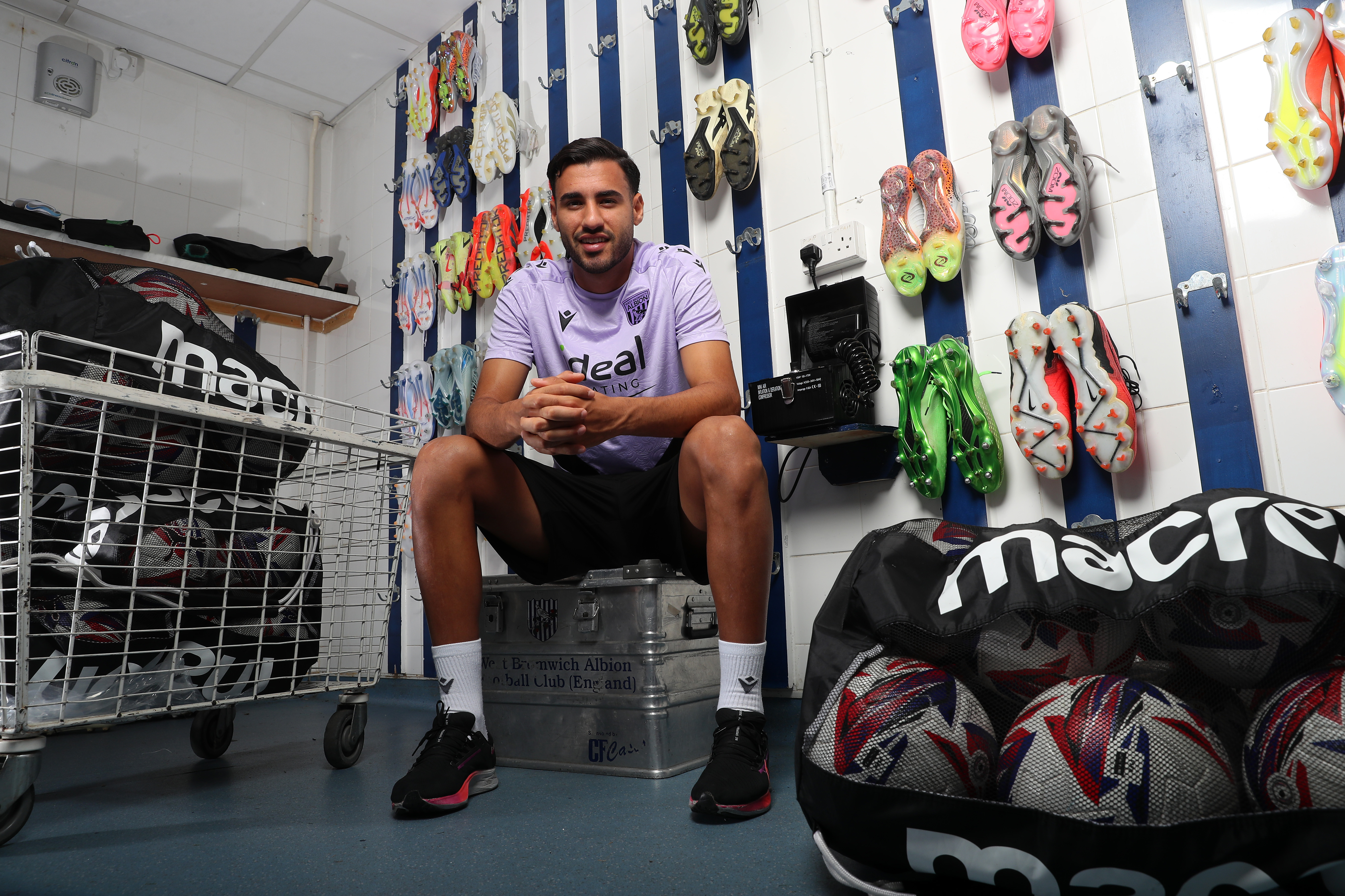 Gianluca Frabotta smiling at the camera while sat in the boot room