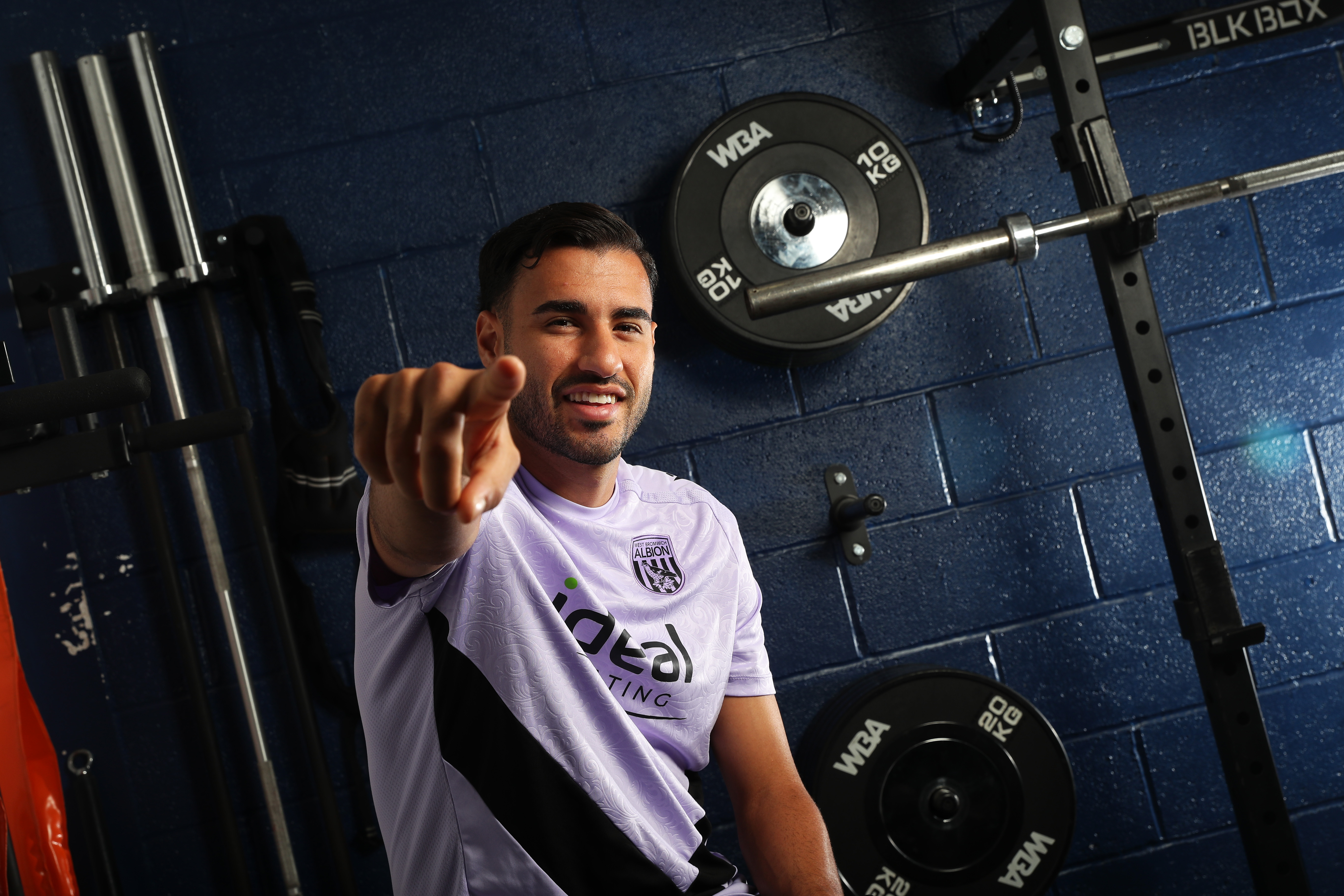 Gianluca Frabotta smiling at the camera while sat in the gym