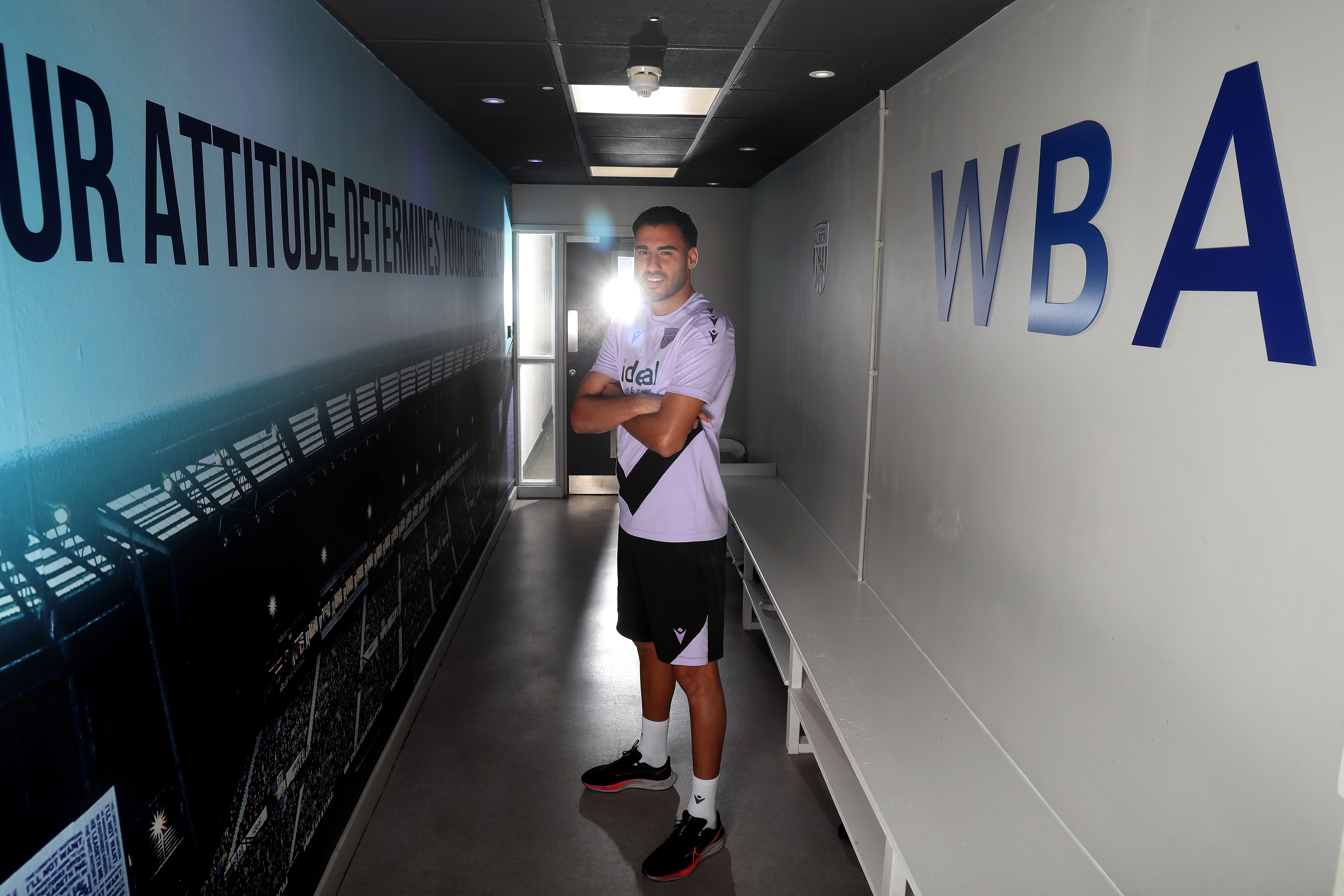 Gianluca Frabotta smiling at the camera while stood in a corridor 