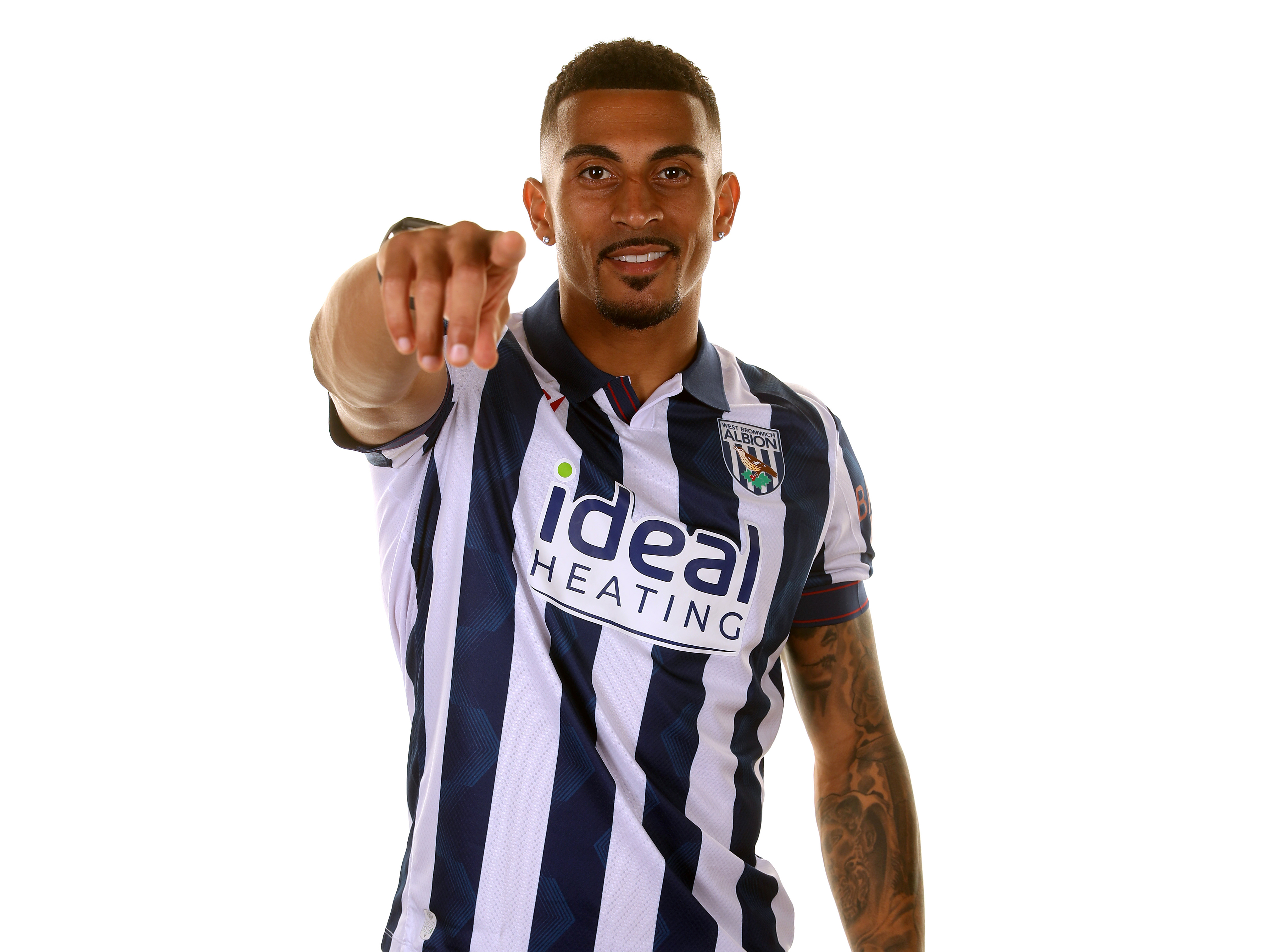 Karlan Grant smiling and pointing at the camera wearing the home shirt