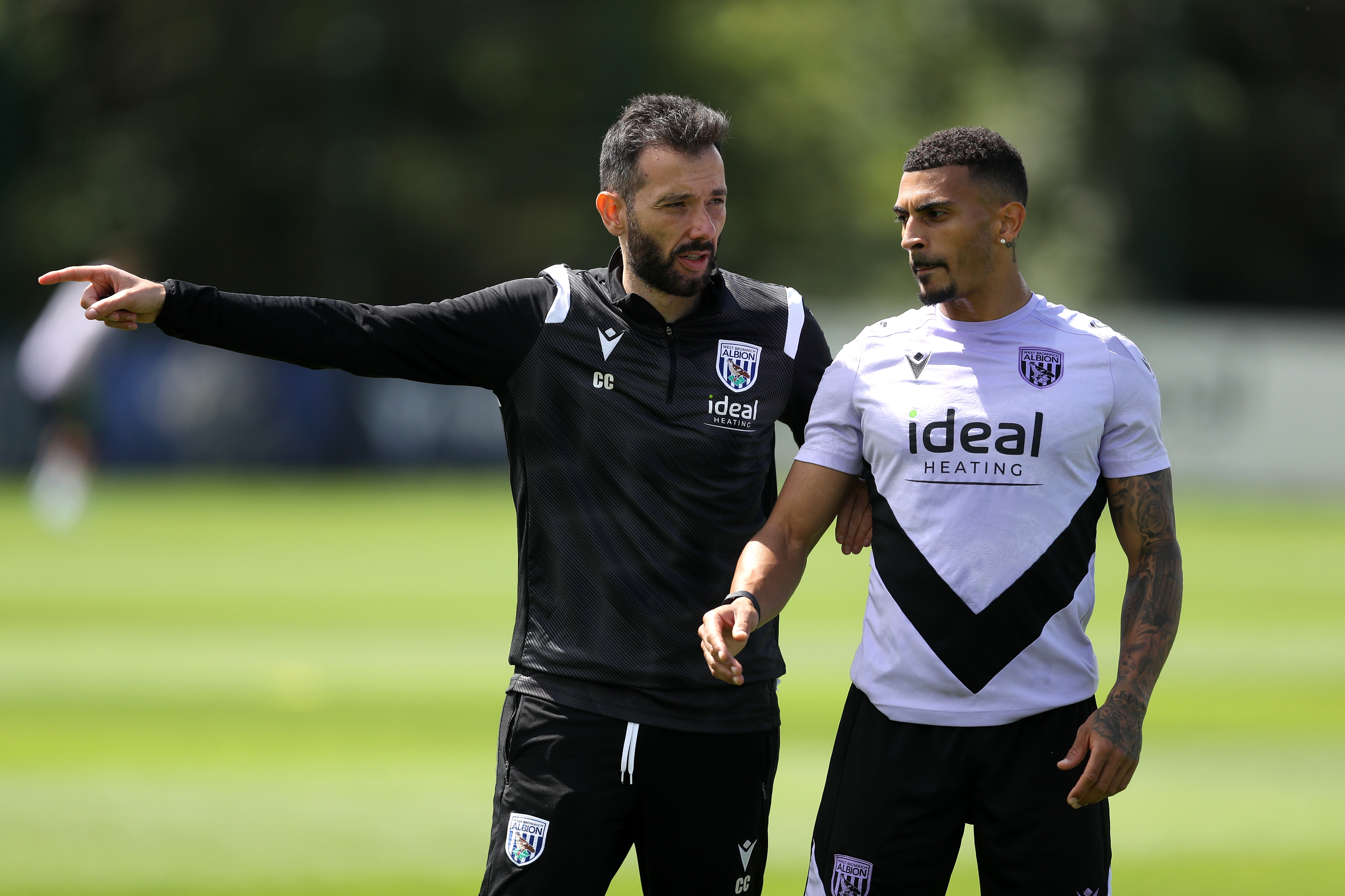 Carlos Corberán giving instructions to Karlan Grant during a training session 