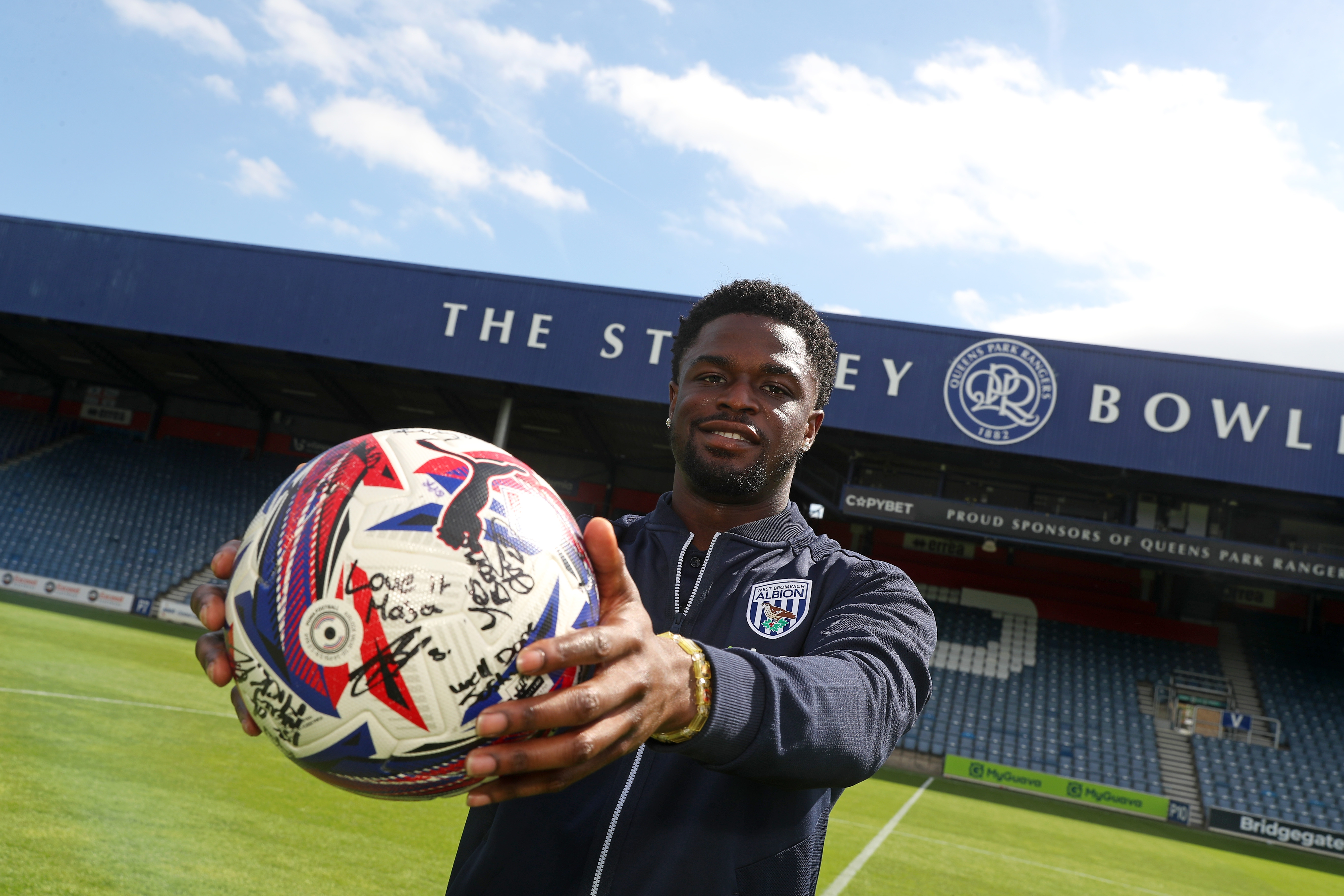 Josh Maja smiling at the camera while holding the match ball at QPR 