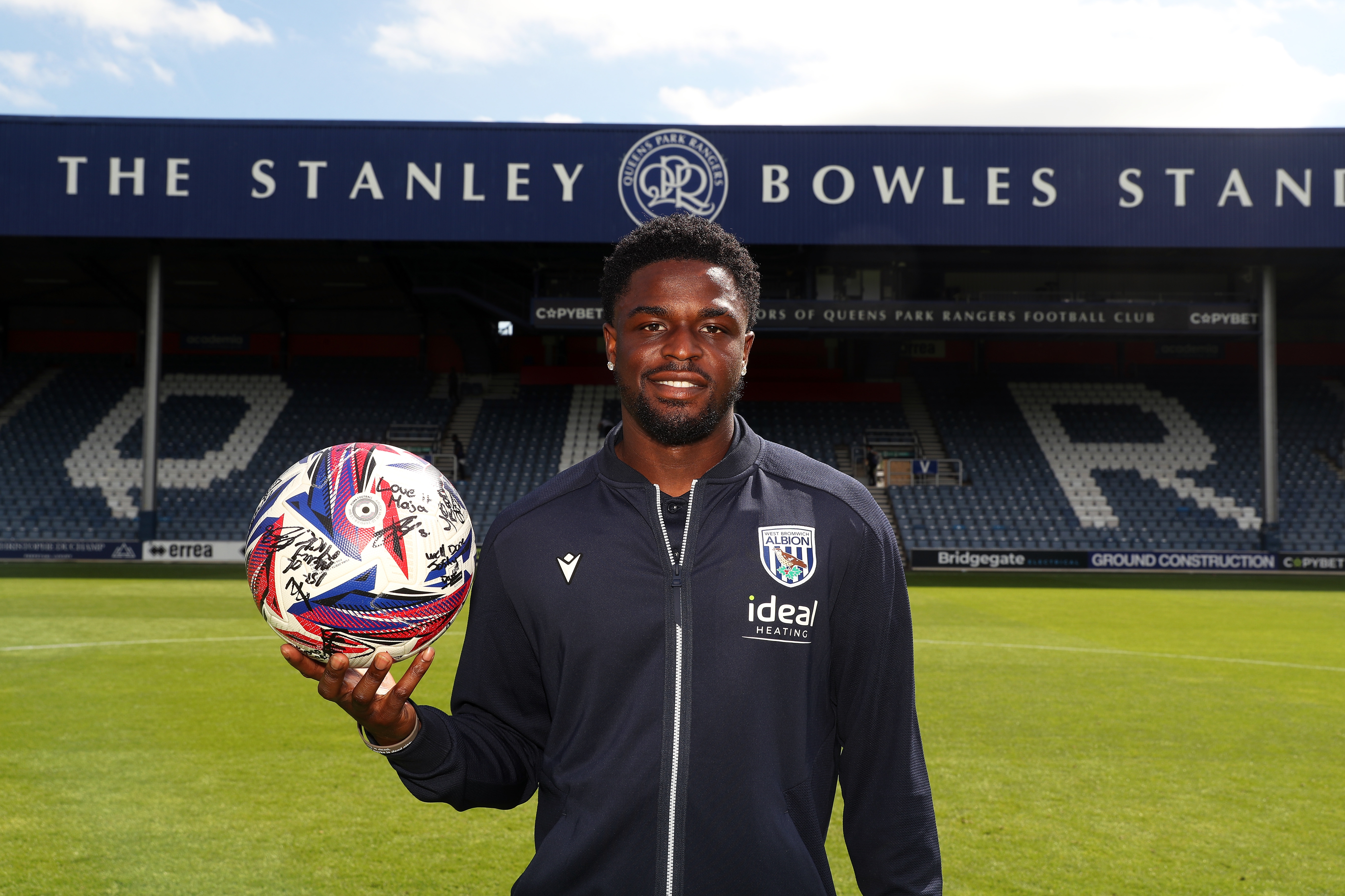 Josh Maja smiling at the camera while holding the match ball at QPR 