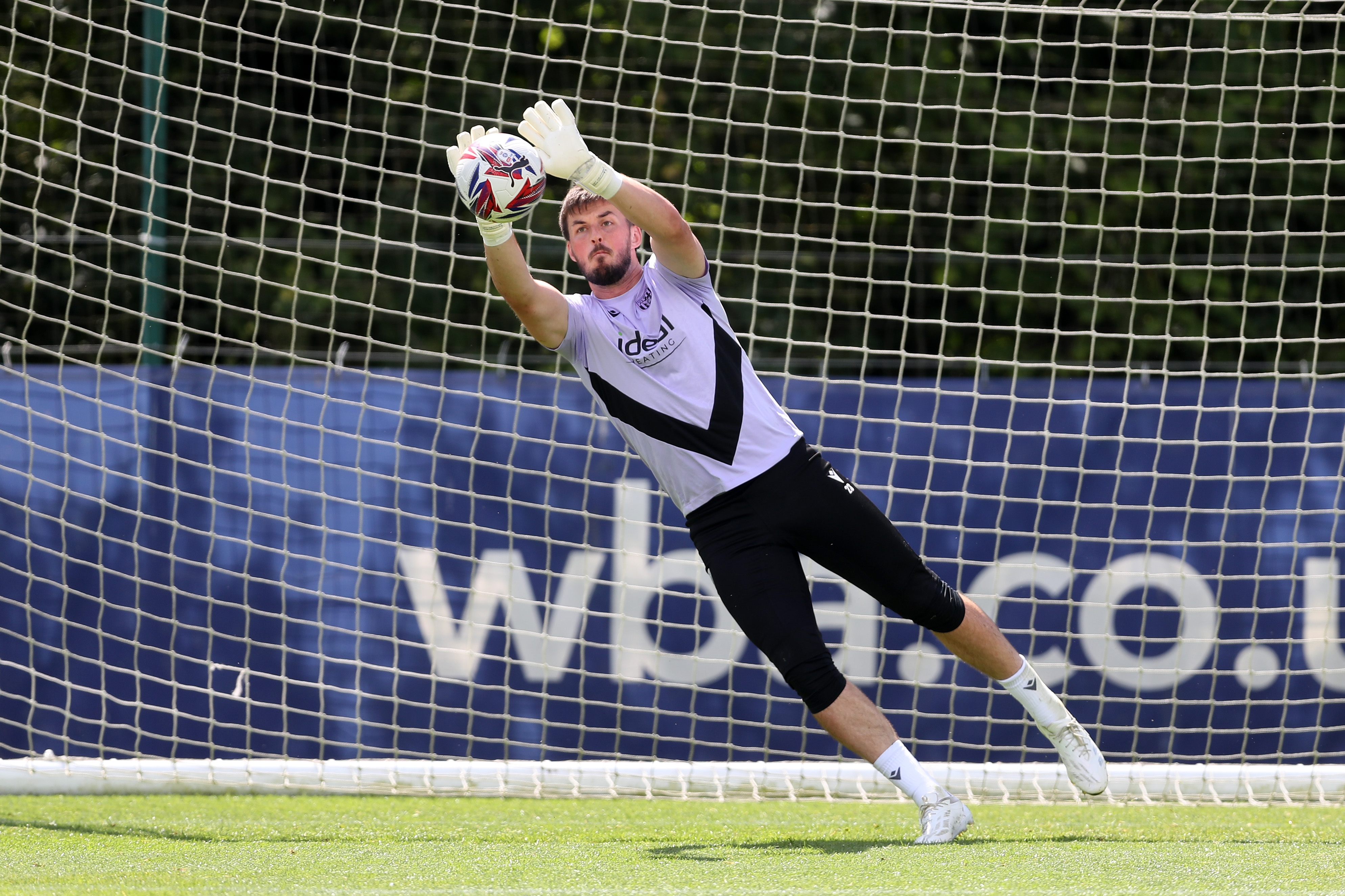 Joe Wildsmith diving to catch a ball during training 