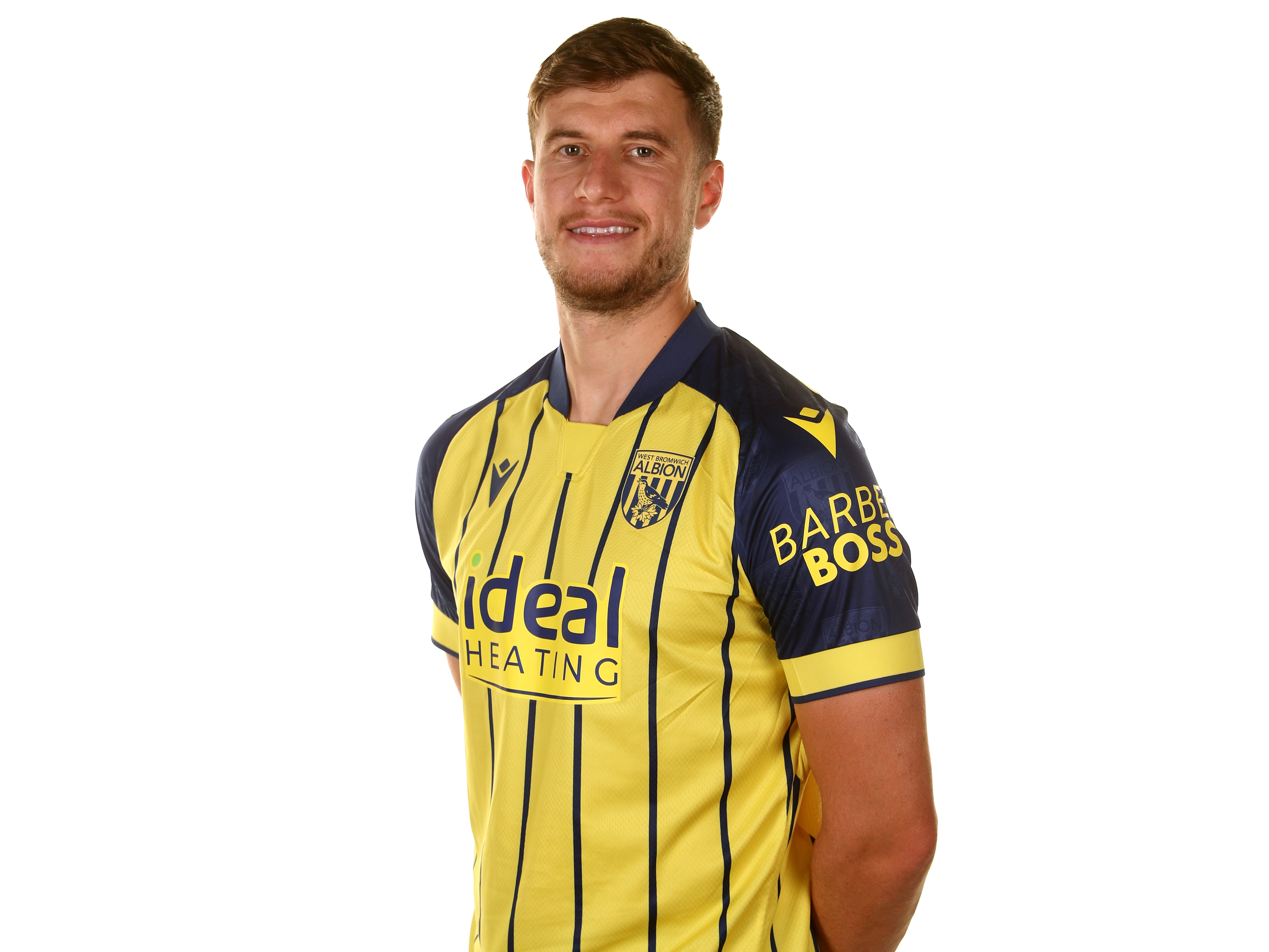 Paddy McNair smiling at the camera while wearing the yellow away shirt 