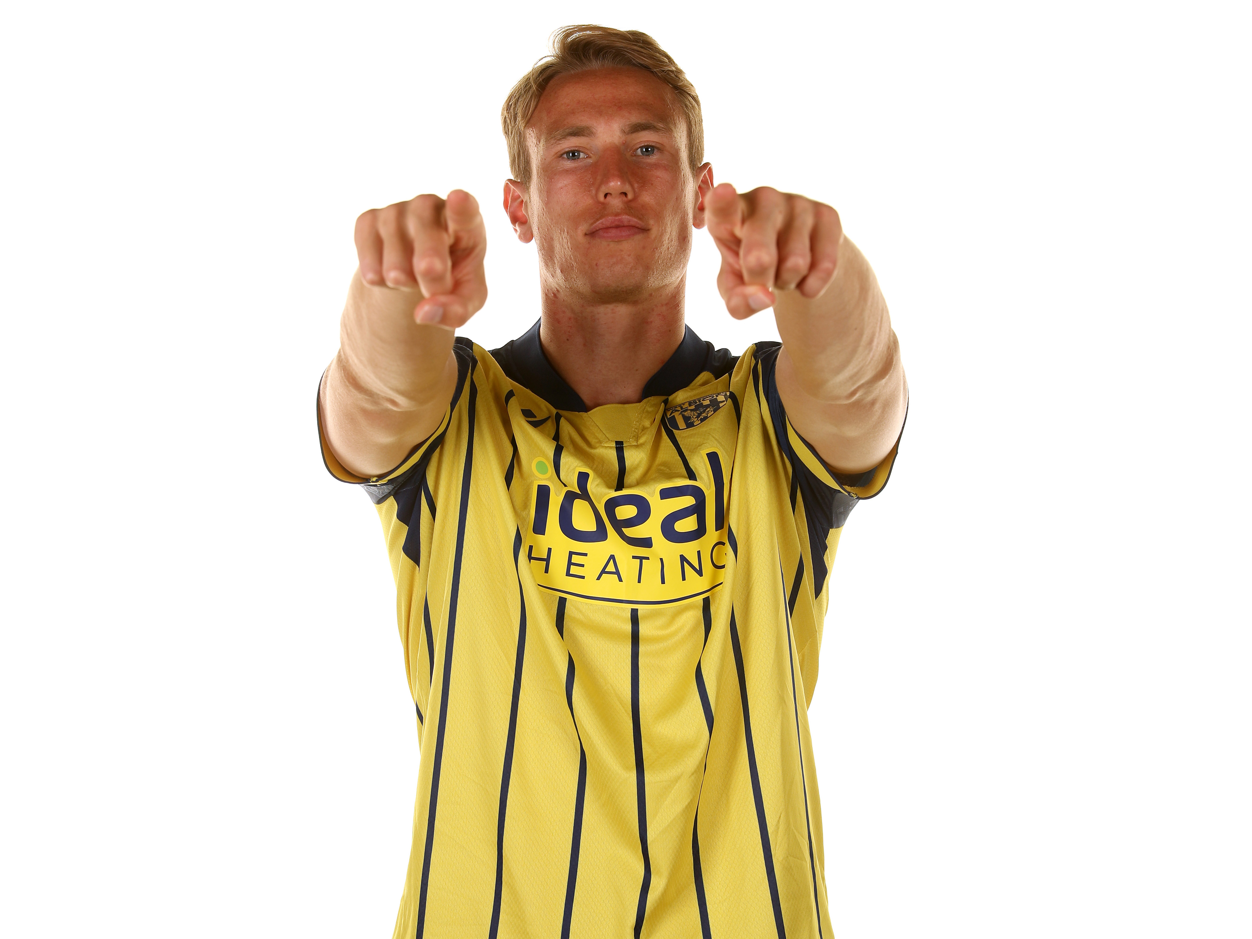 Torbjørn Heggem pointing and looking at the camera while wearing the yellow away shirt 