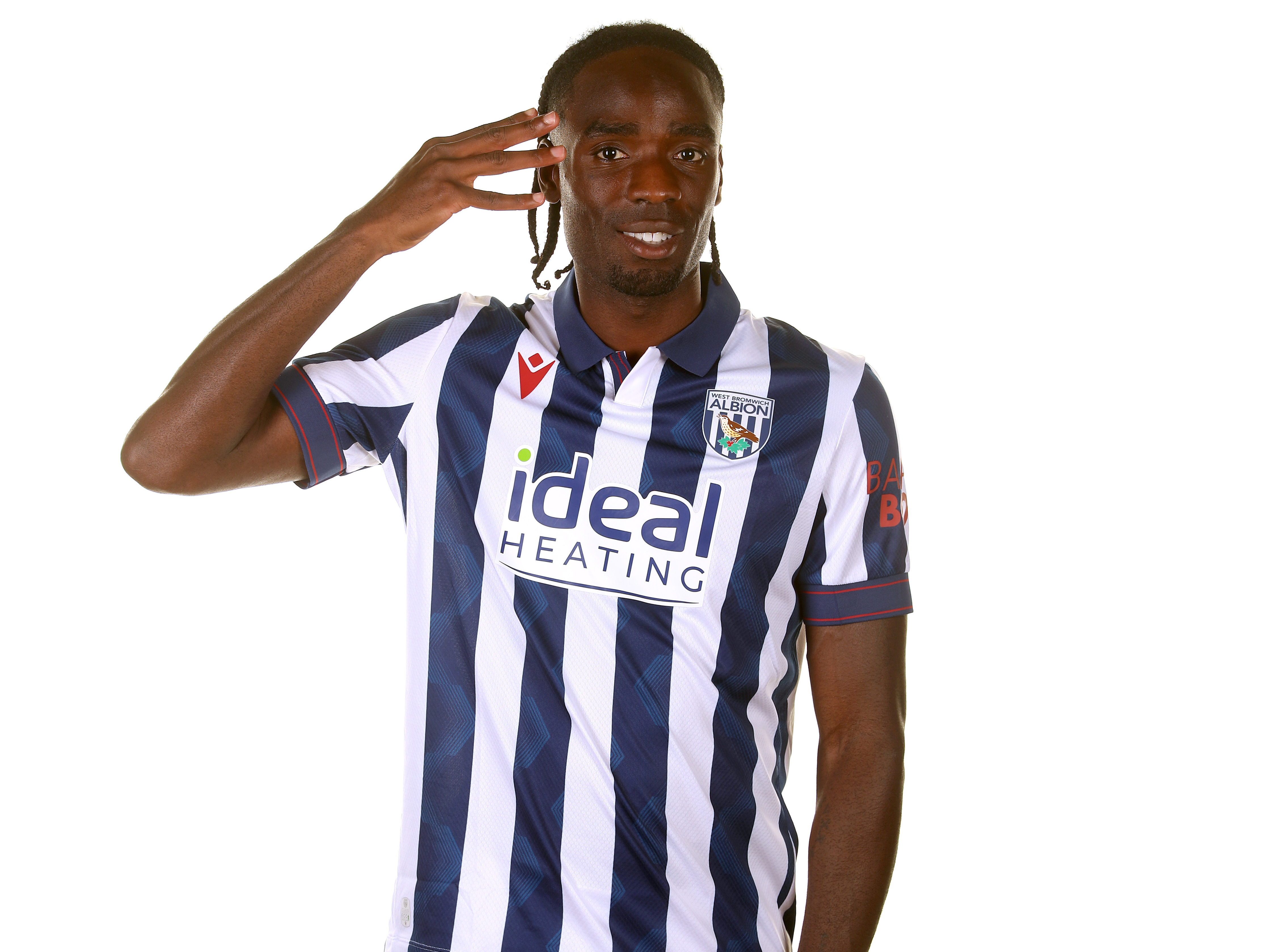 Devante Cole smiling at the camera in a home shirt holding his hand to his ear 