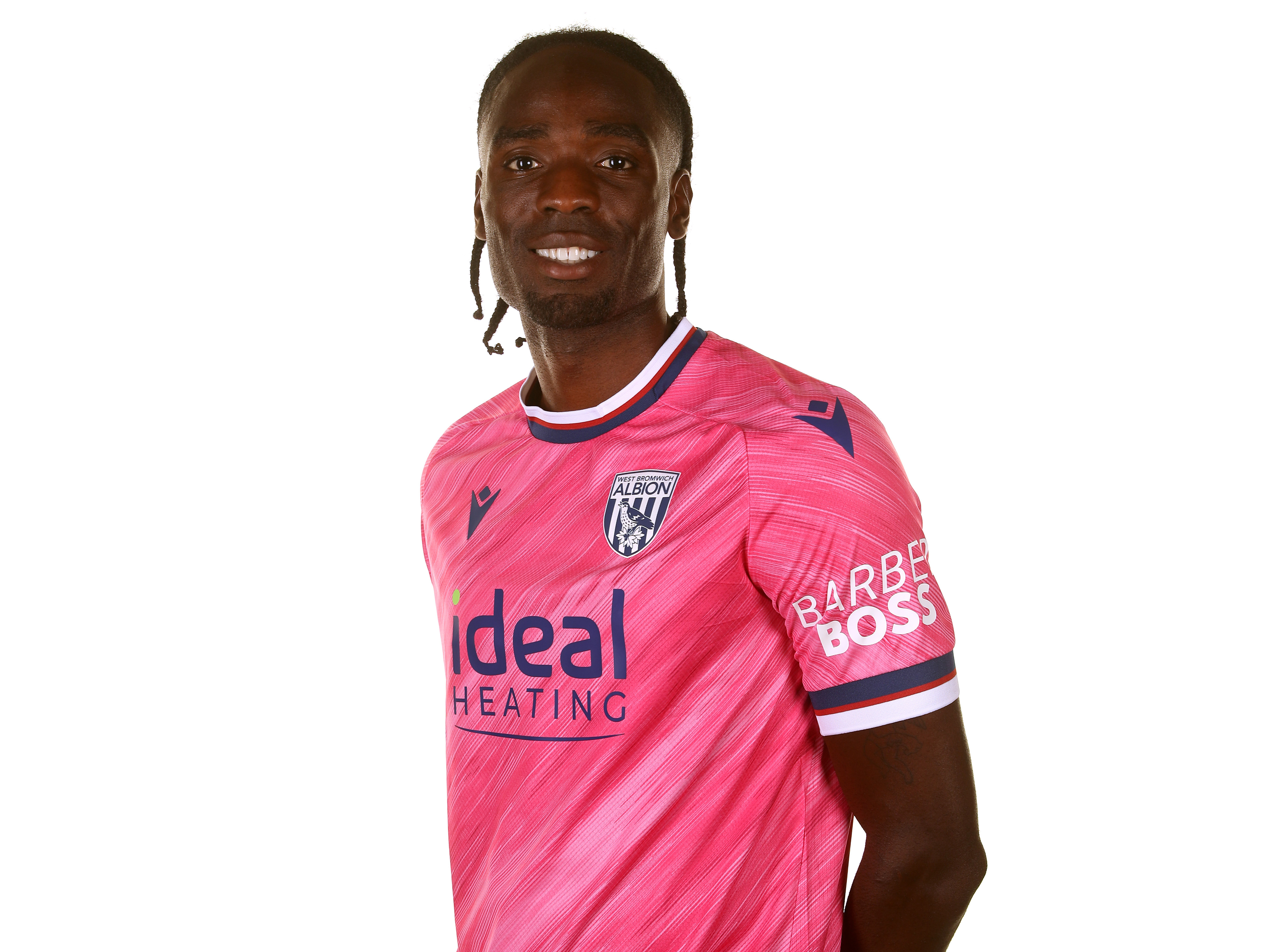 Devante Cole smiling at the camera while wearing the pink away shirt 