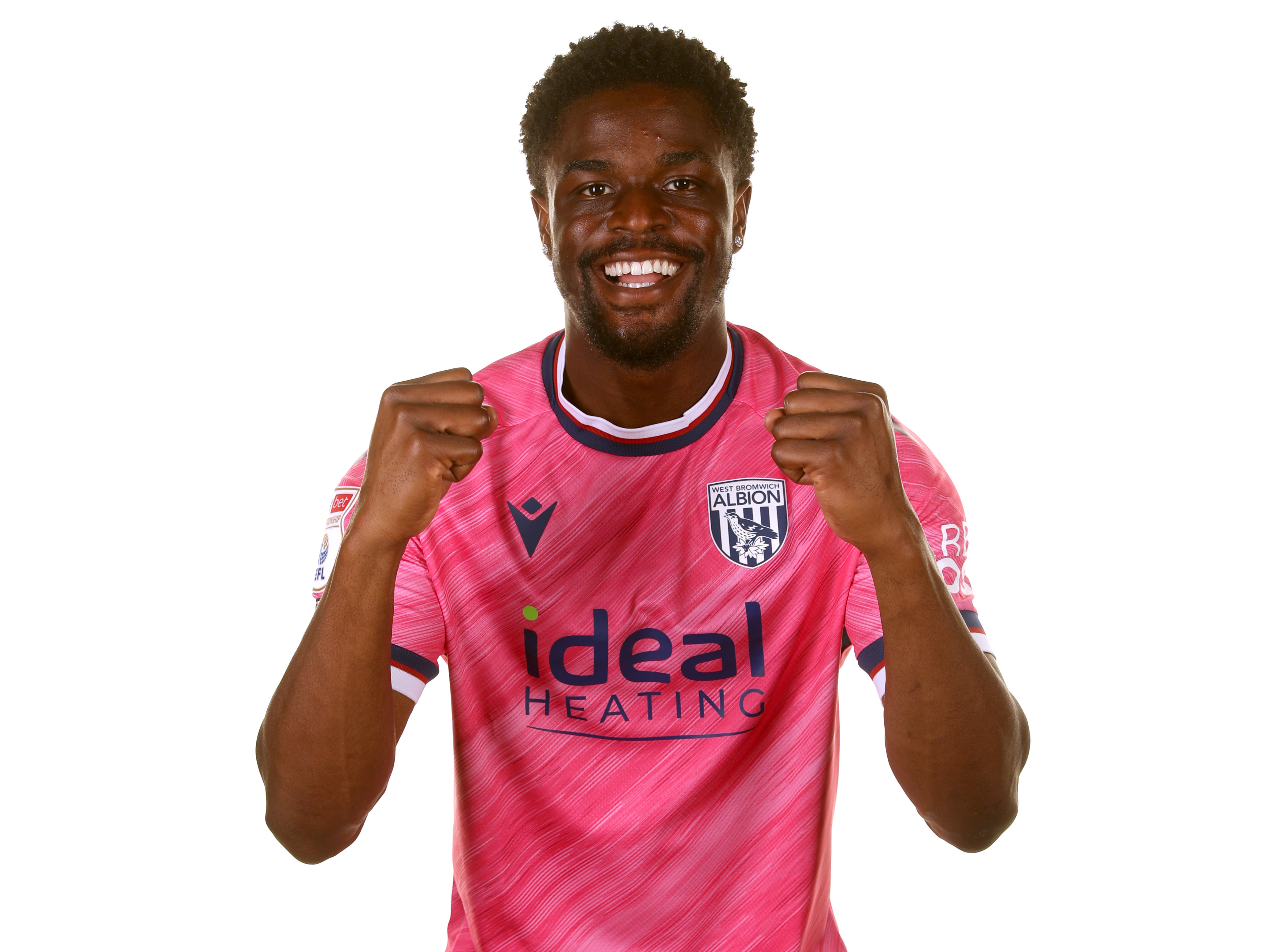 Josh Maja smiling at the camera with his fists clenched while wearing the pink shirt 