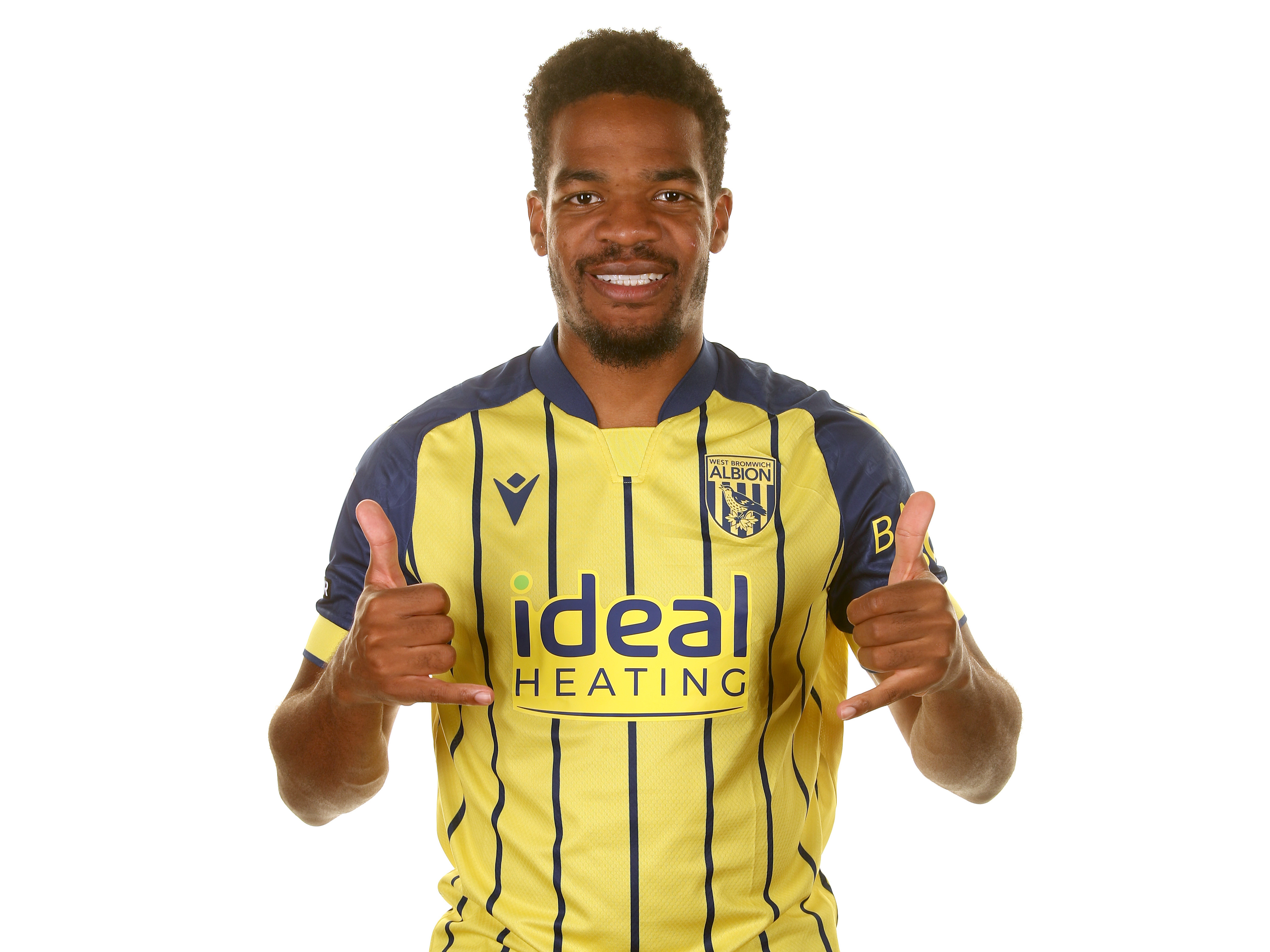 Grady Diangana smiling at the camera while wearing the yellow away shirt 