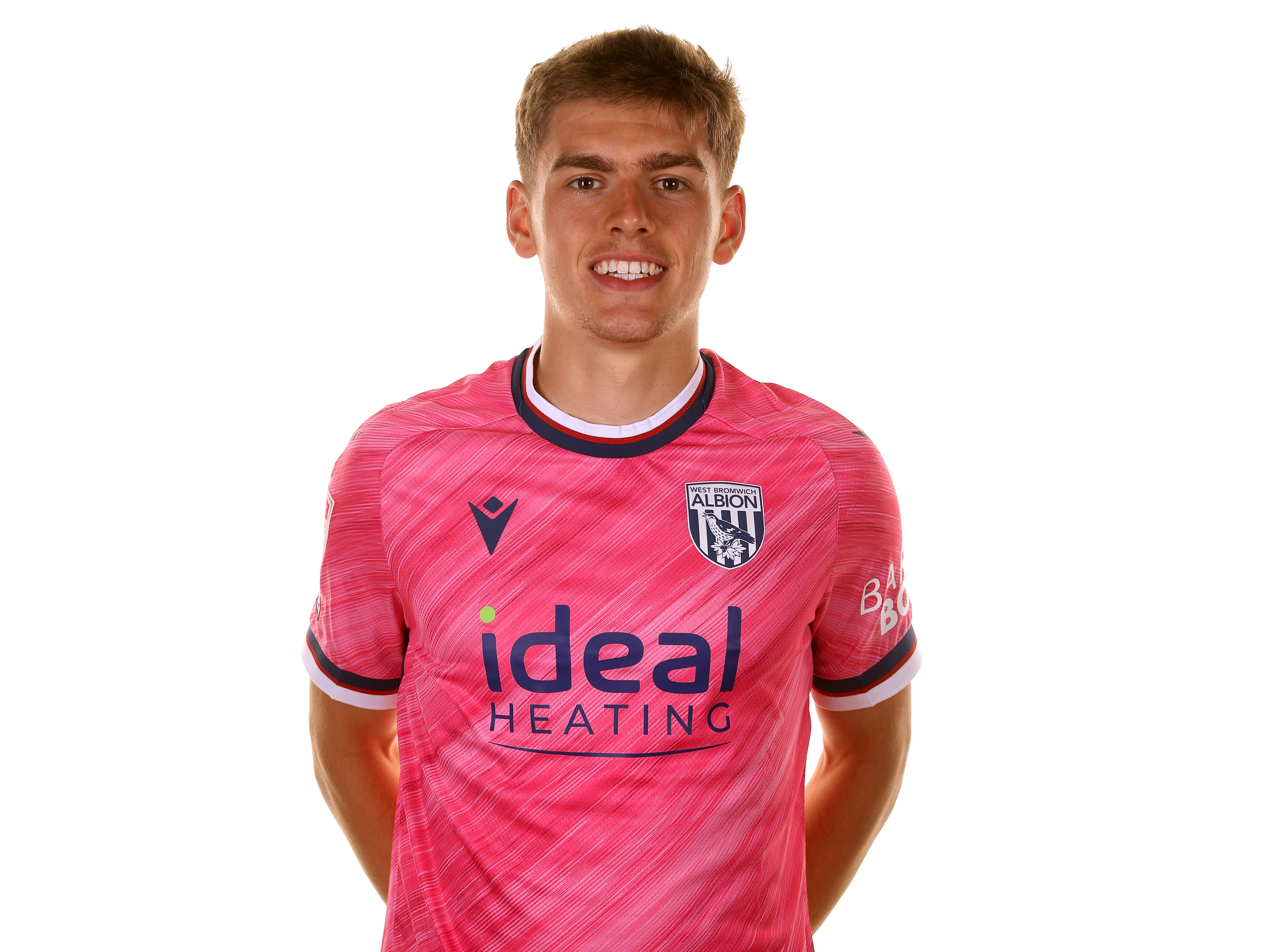 Tom Fellows smiling at the camera while wearing the pink away shirt