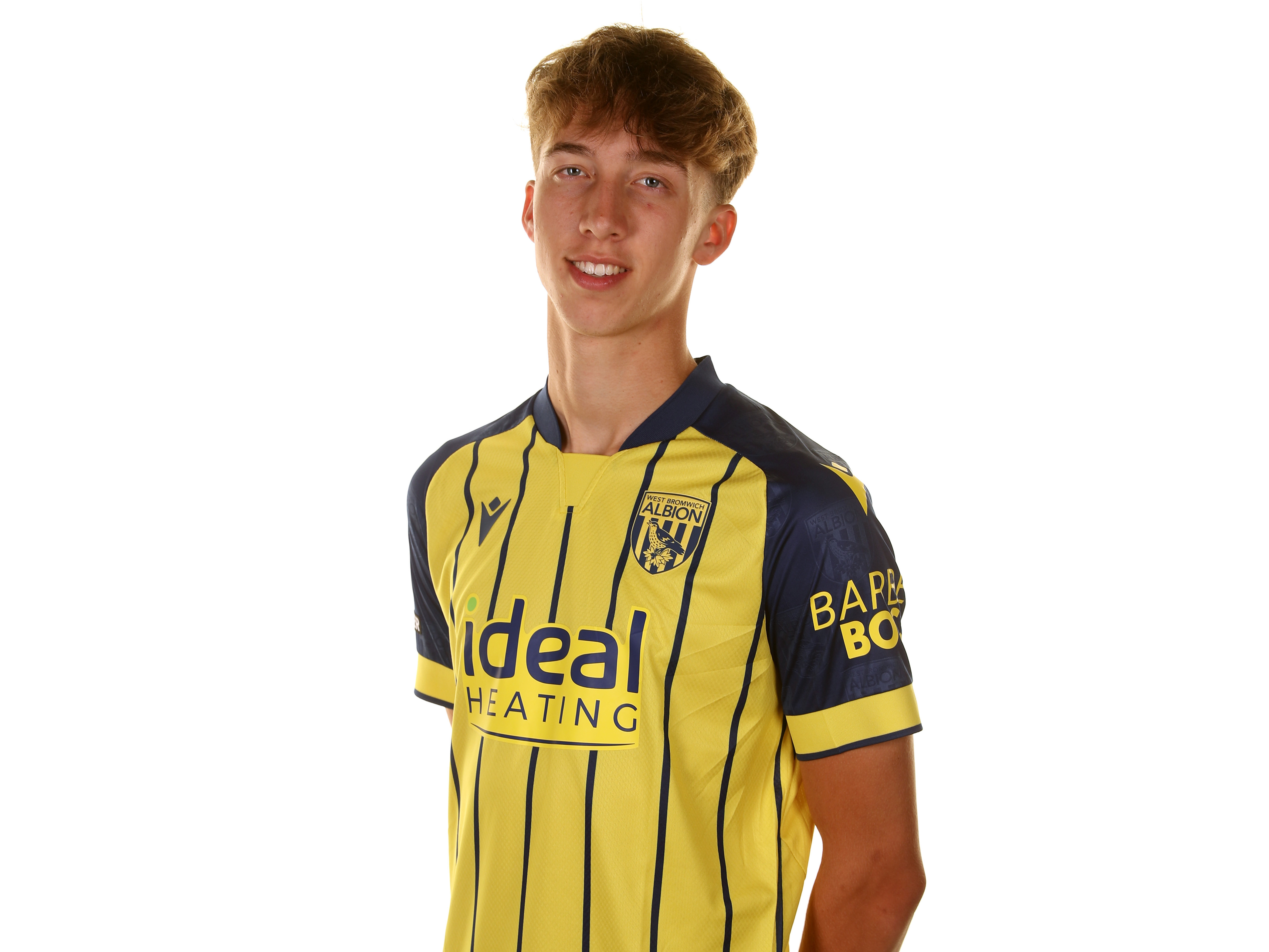 Harry Whitwell smiling at the camera while wearing the yellow away shirt 