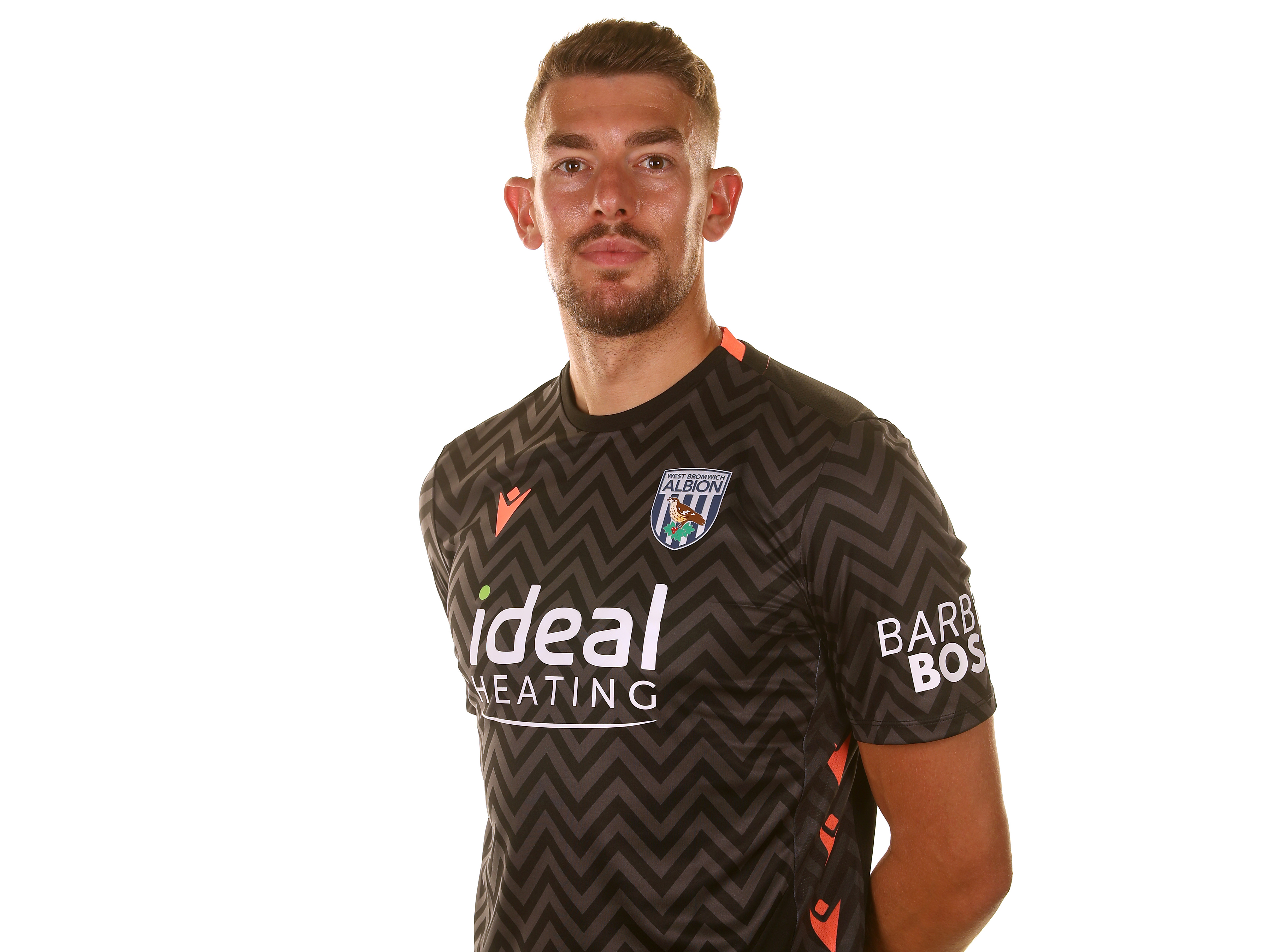 Alex Palmer smiling at the camera while wearing the black goalkeeper shirt 