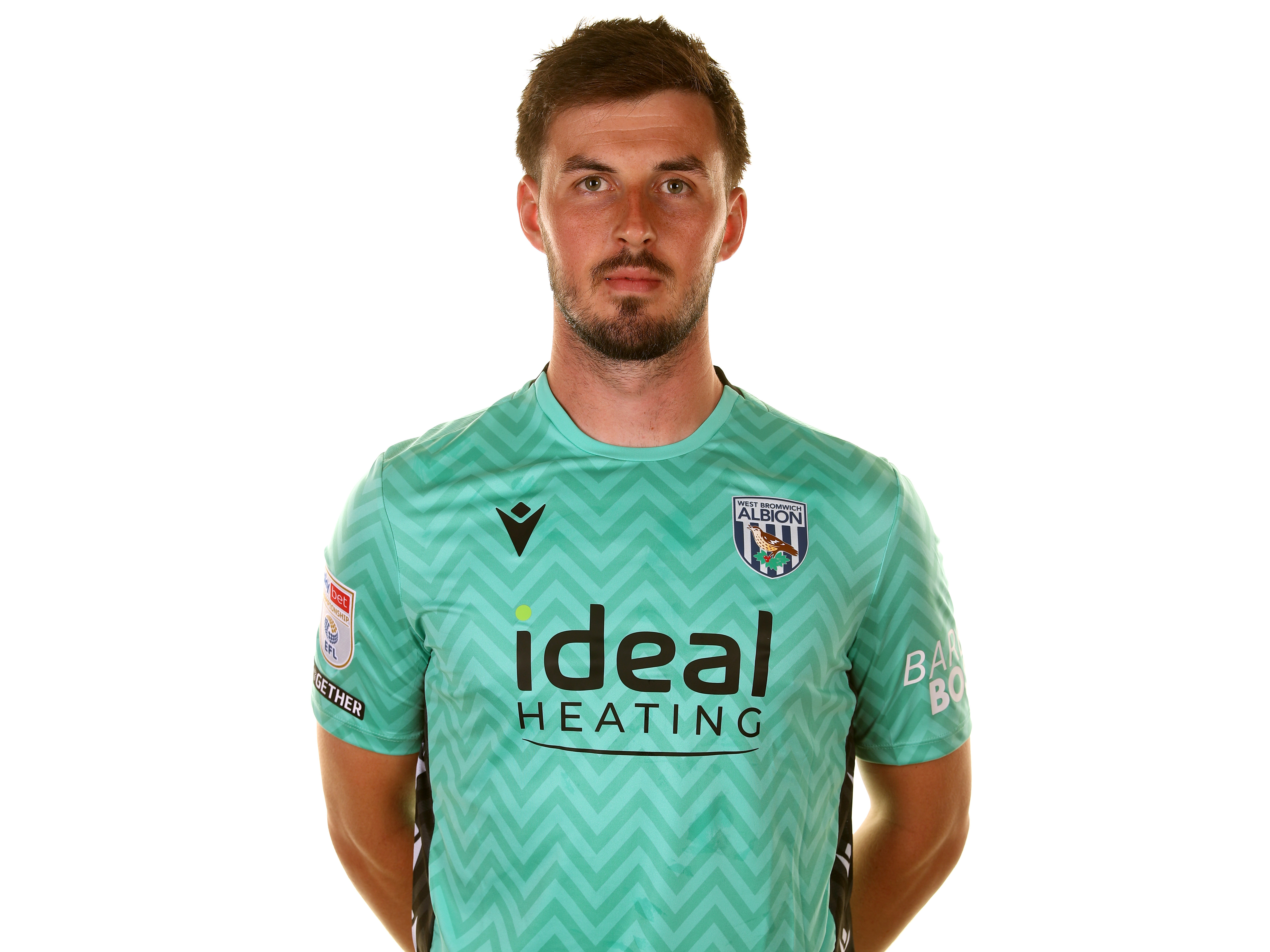 Joe Wildsmith looking at the camera while wearing the green goalkeeper kit 