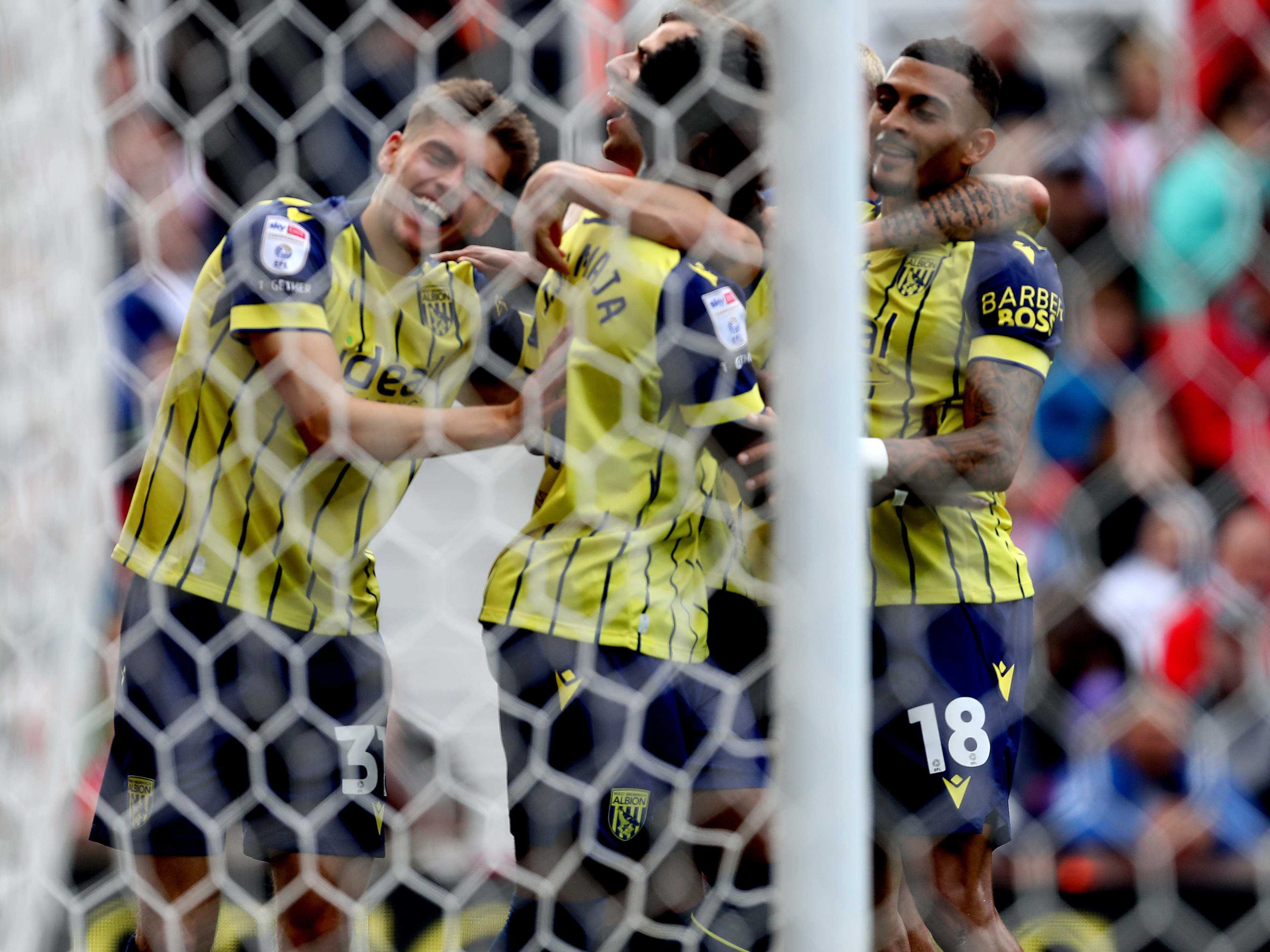 A photo of Albion players in the yellow and blue 2024/25 away kit against Stoke City