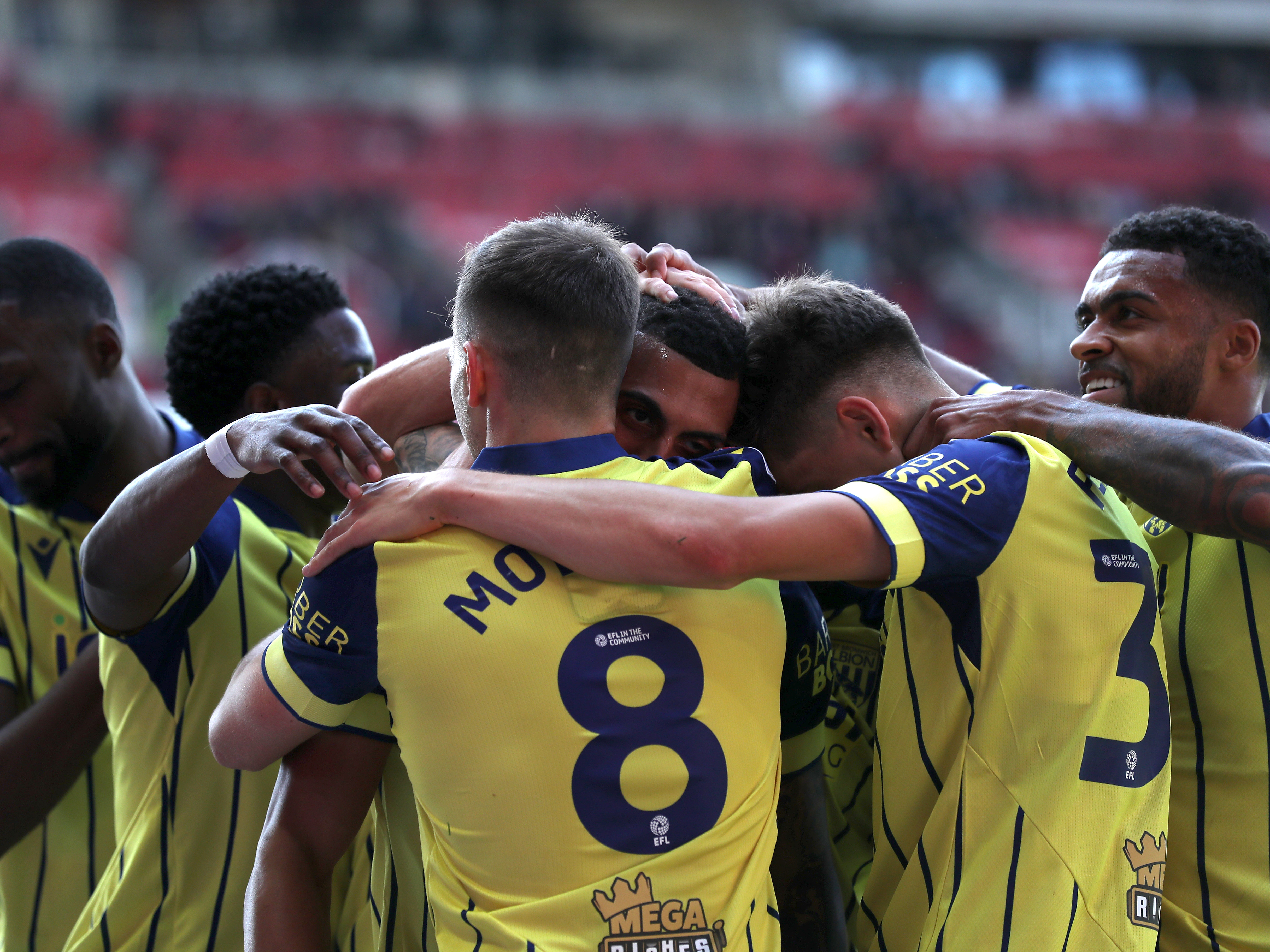 A photo of Albion players in the yellow and blue 2024/25 away kit against Stoke City