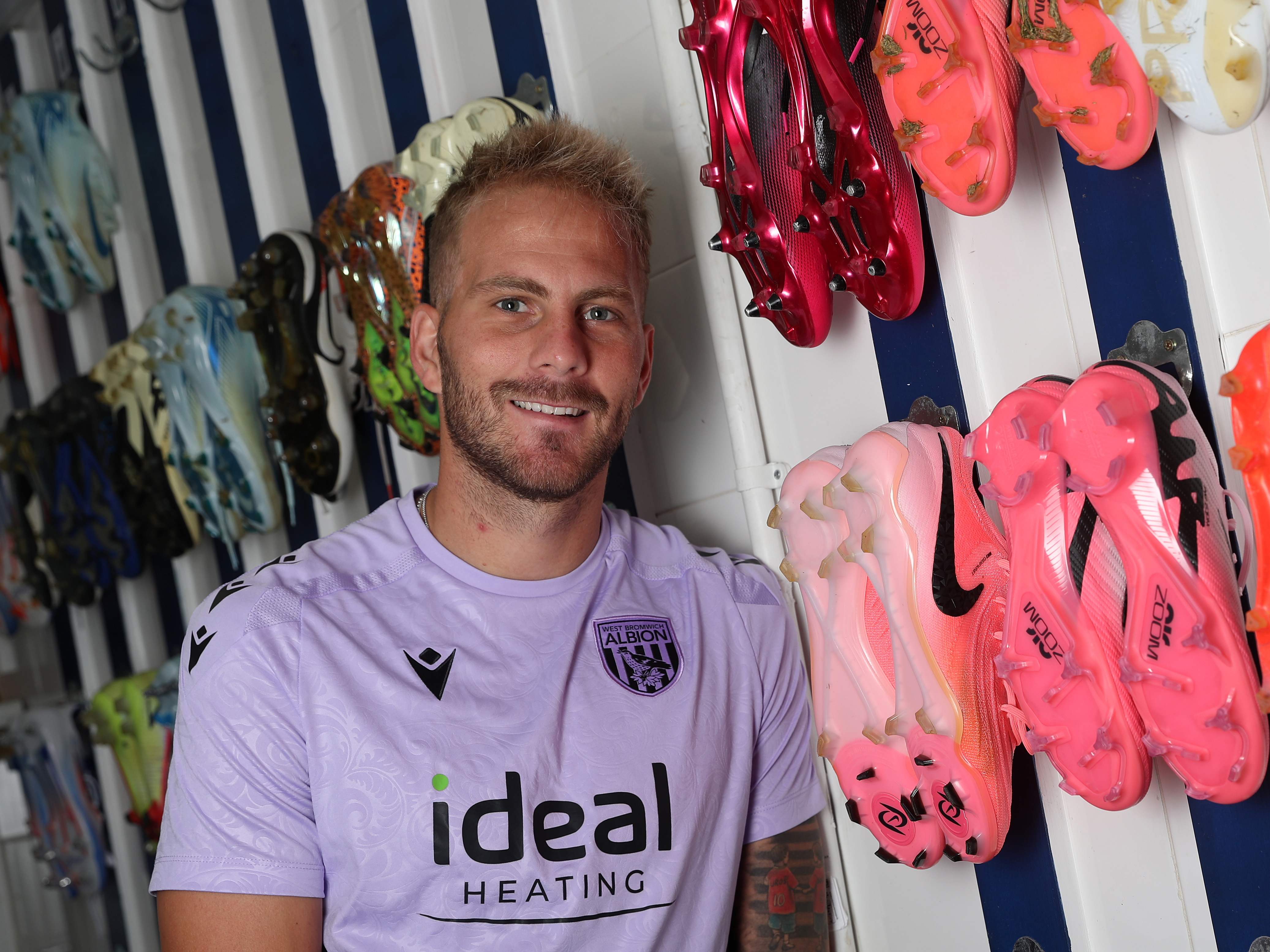 Uroš Račić smiling at the camera while sat in the boot room