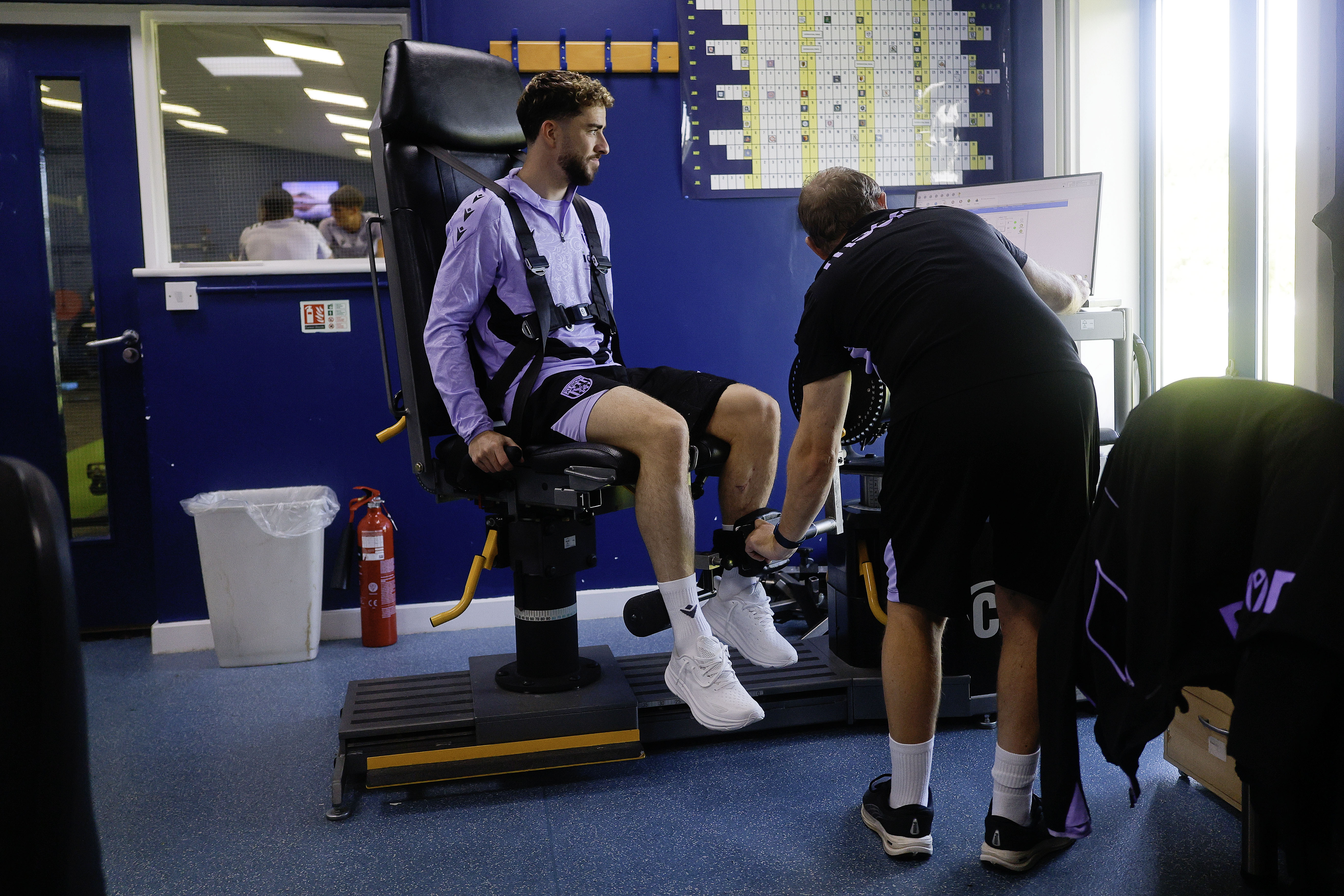 Mikey Johnston sat in a medical chair going through tests with a member of staff