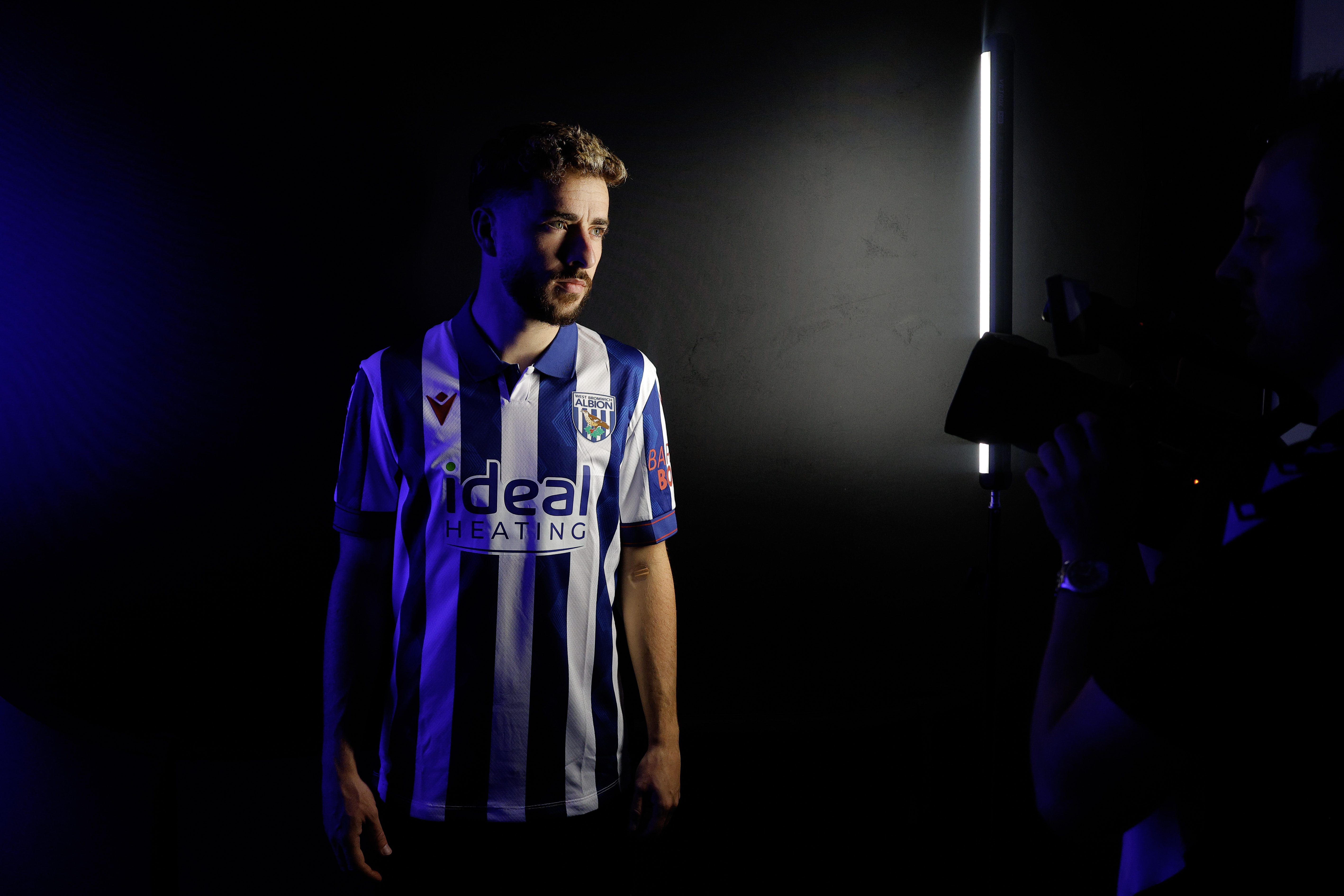 Mikey Johnston stood in a TV studio in a home shirt 