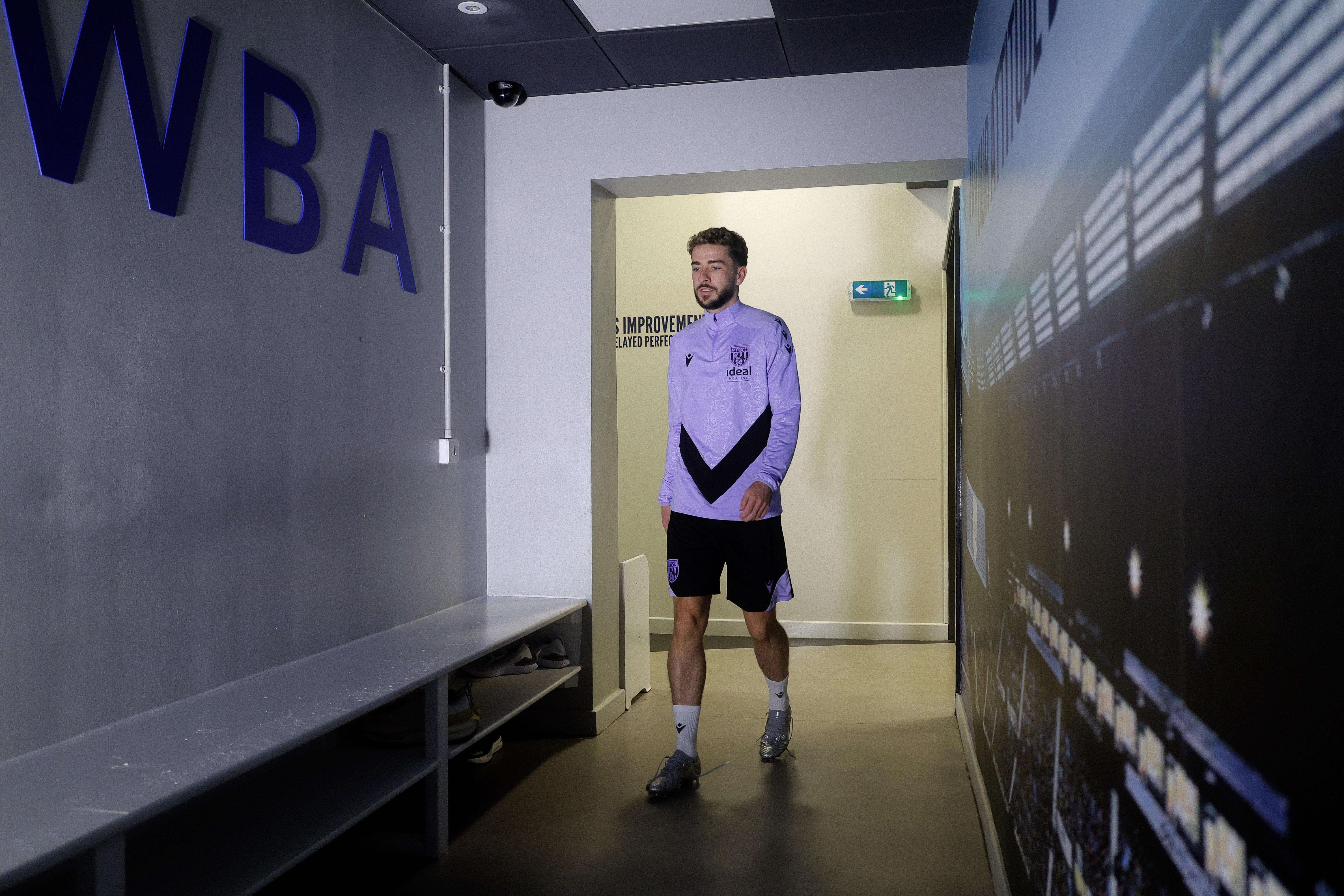 Mikey Johnston walking through a corridor at the training ground 