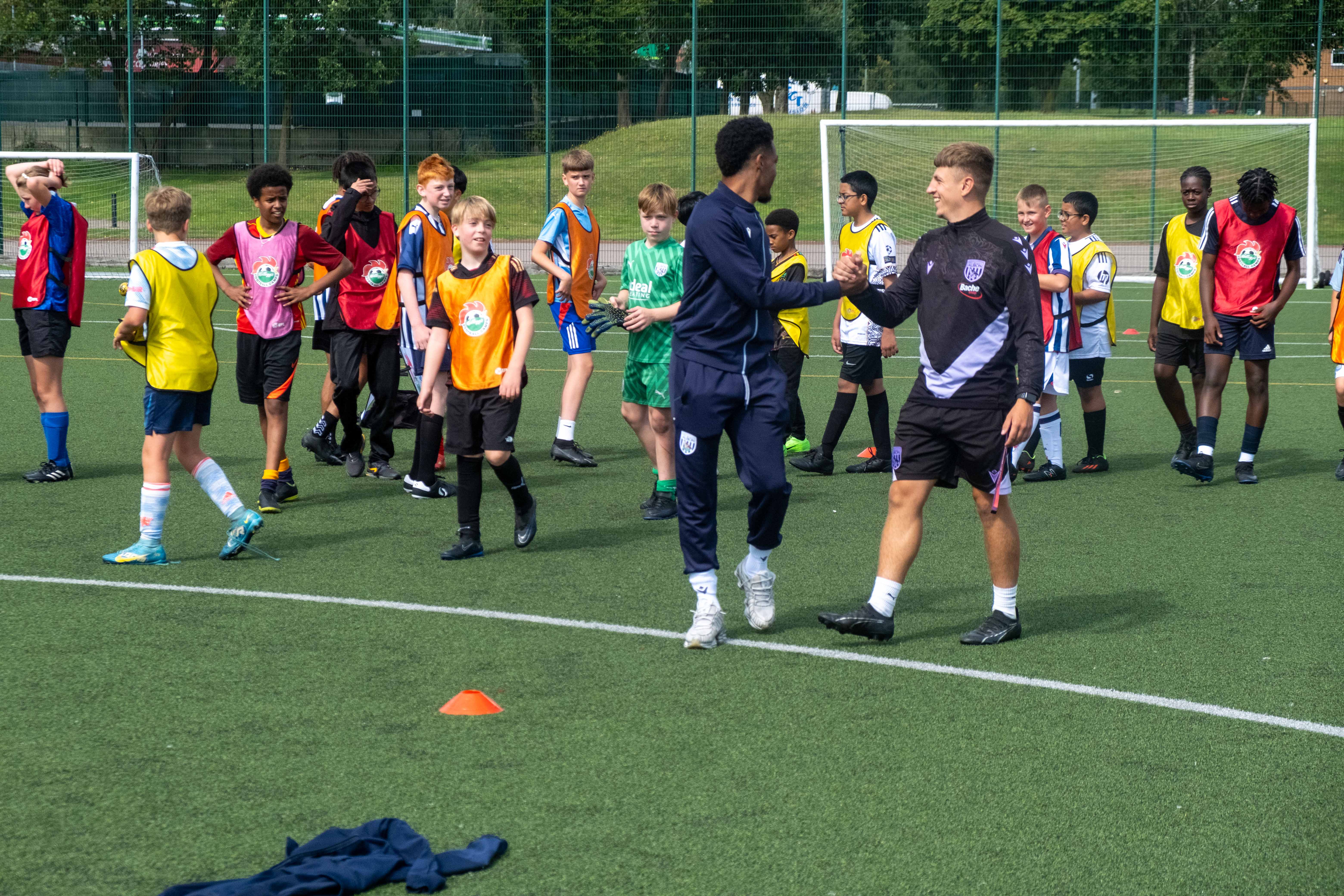 Grady Diangana shakes hands with Foundation coach Rhys Warner.