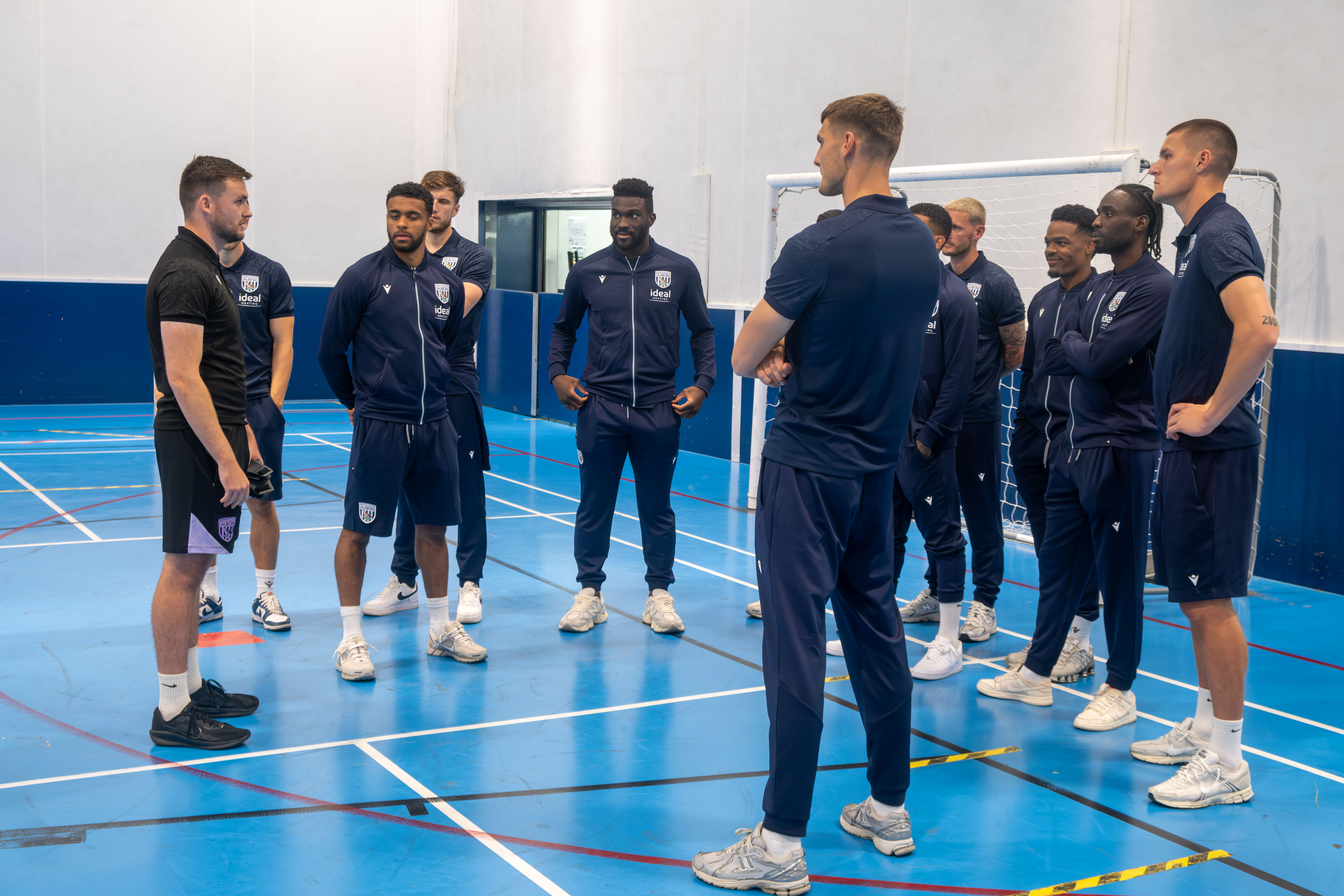 Albion first team players receive a blind football explanation from coach Rich Henderson.