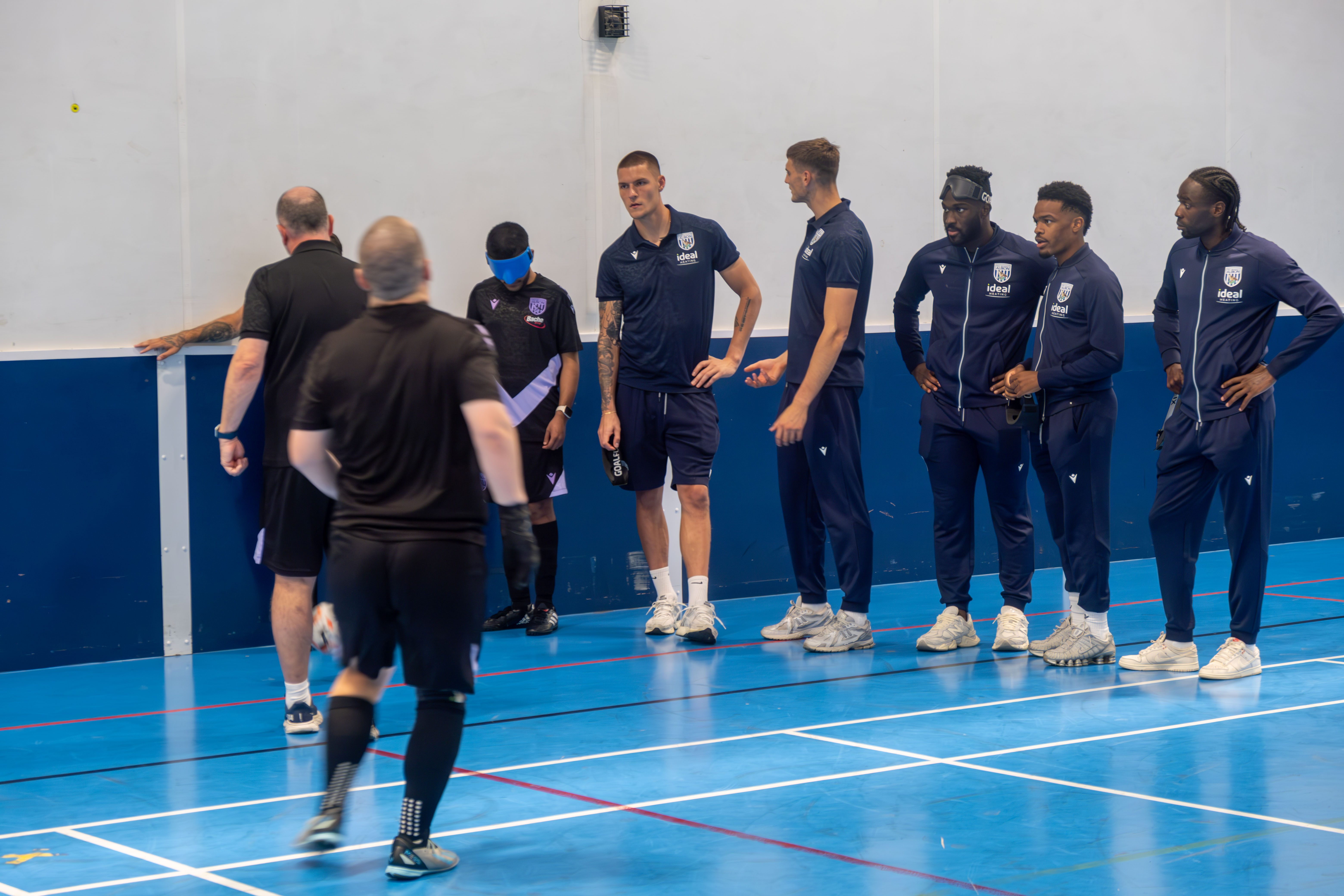 Albion first team players receive a blind football explanation.