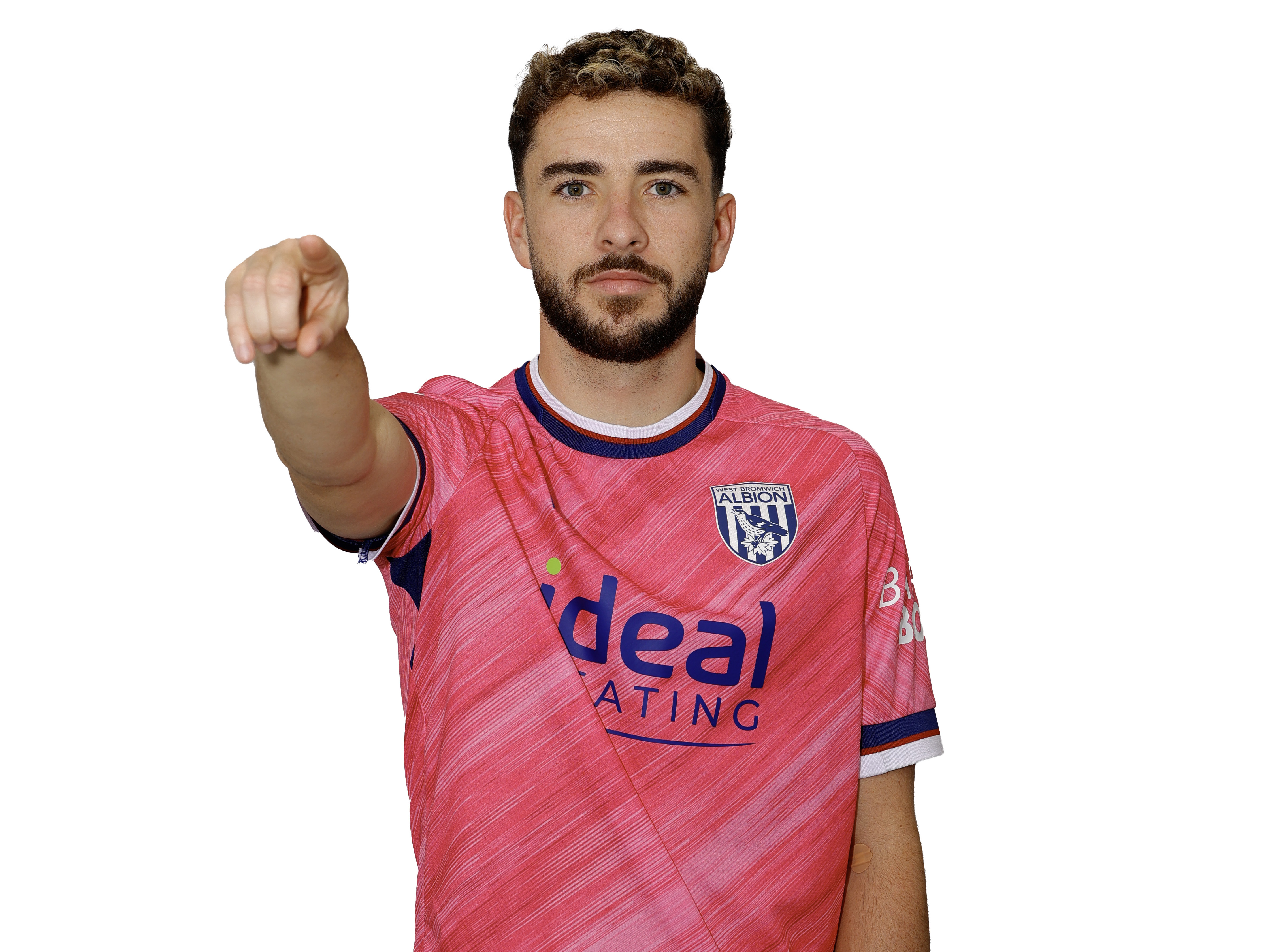 Mikey Johnston pointing and smiling at the camera while wearing a pink away shirt 