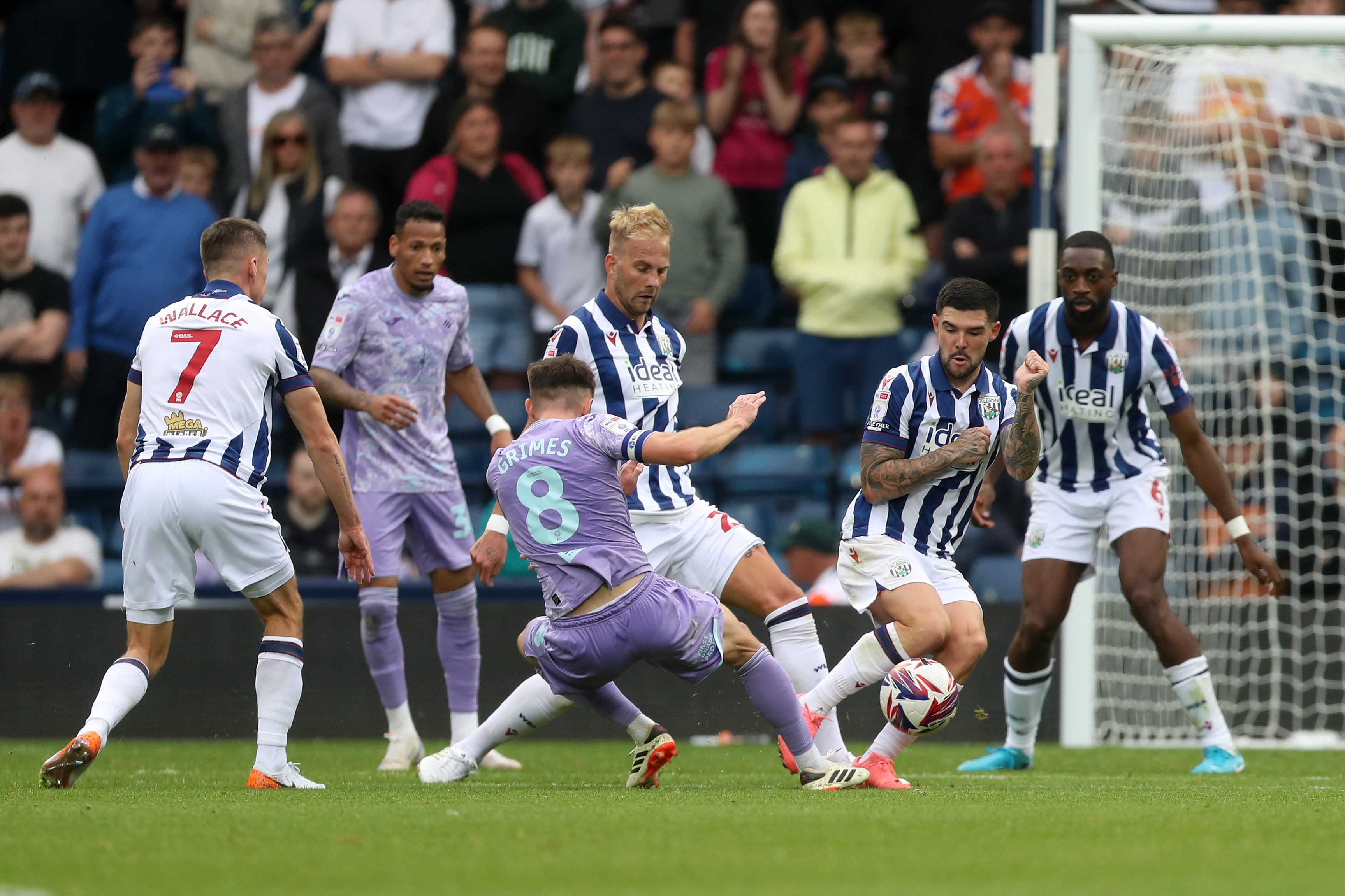 Uroš Račić blocks a shot from a Swansea player with several other players watching in the background