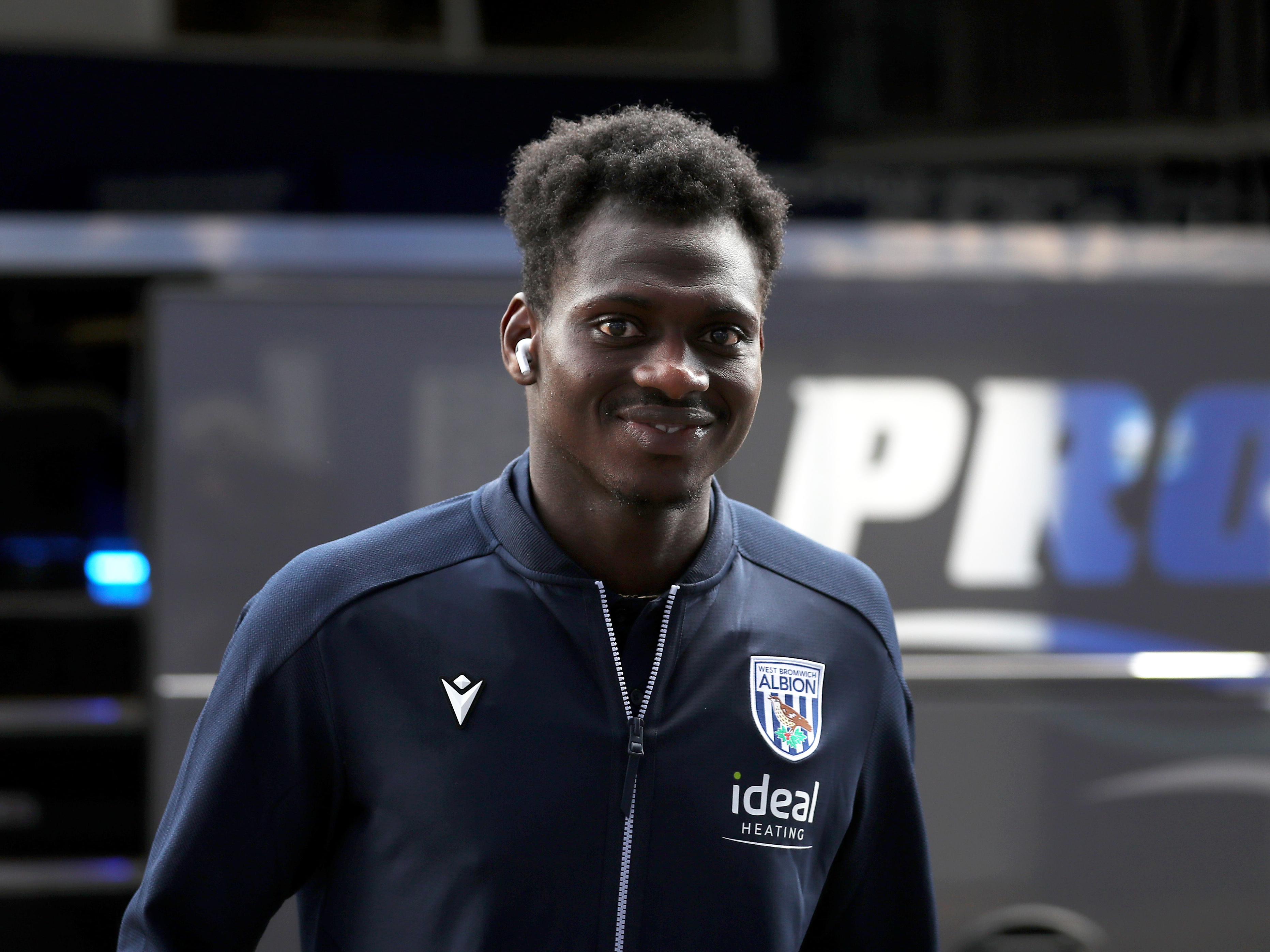 Ousmane Diakité smiling at the camera wearing a club tracksuit 