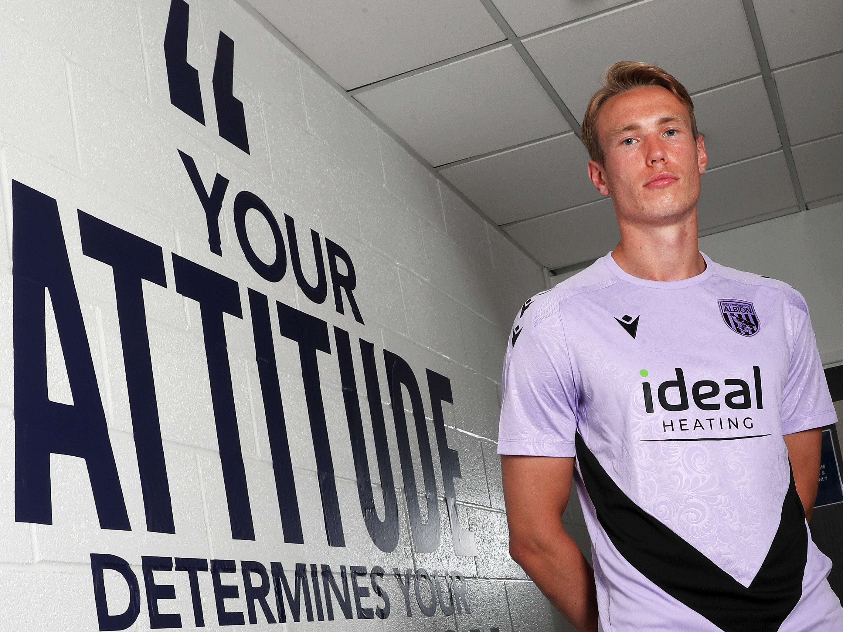 A photo of Torbjorn Heggem in front of a quote at the Albion training ground