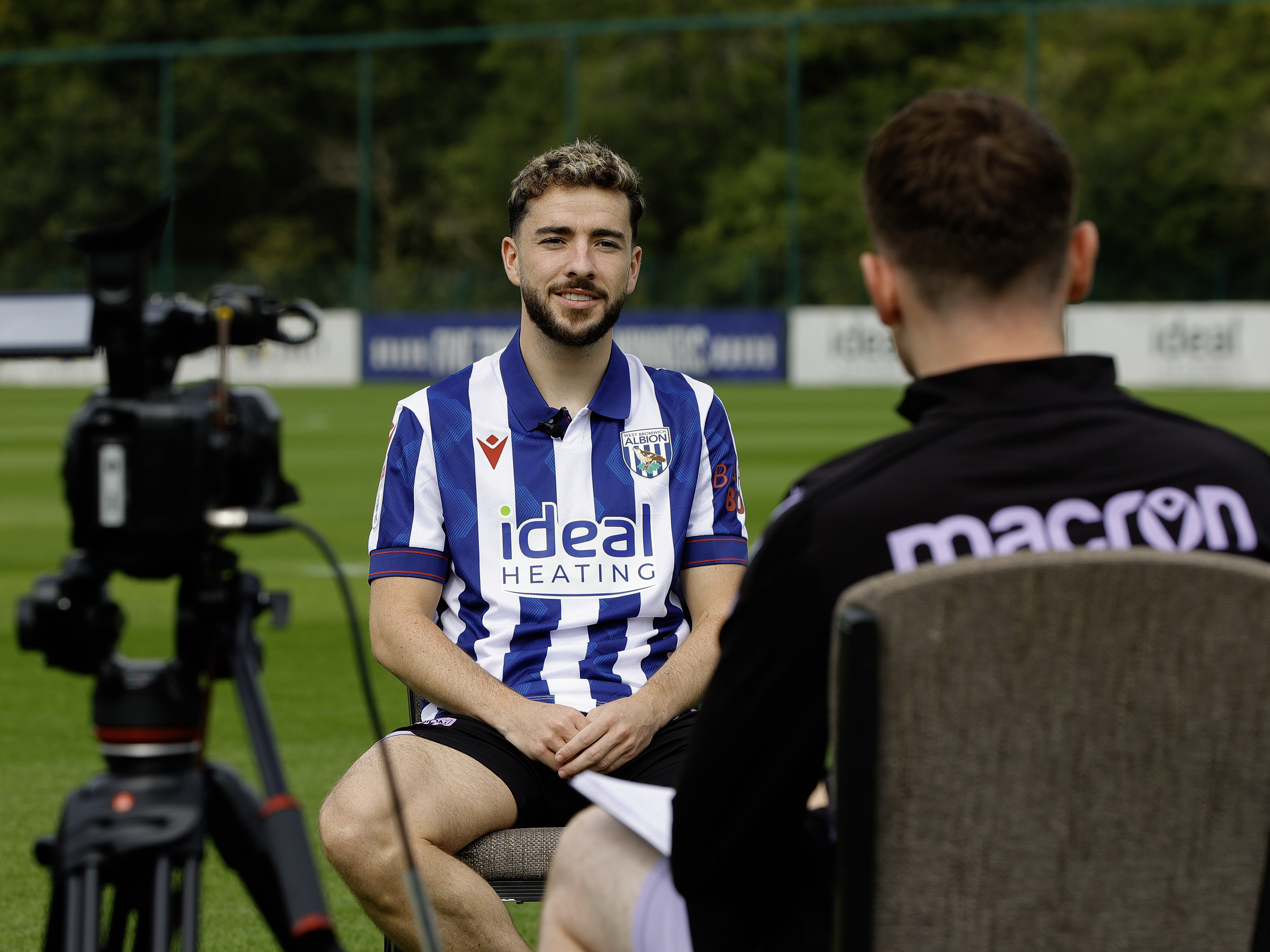 Mikey Johnston is interviewed while saw in a chair in the home shirt on a training pitch 