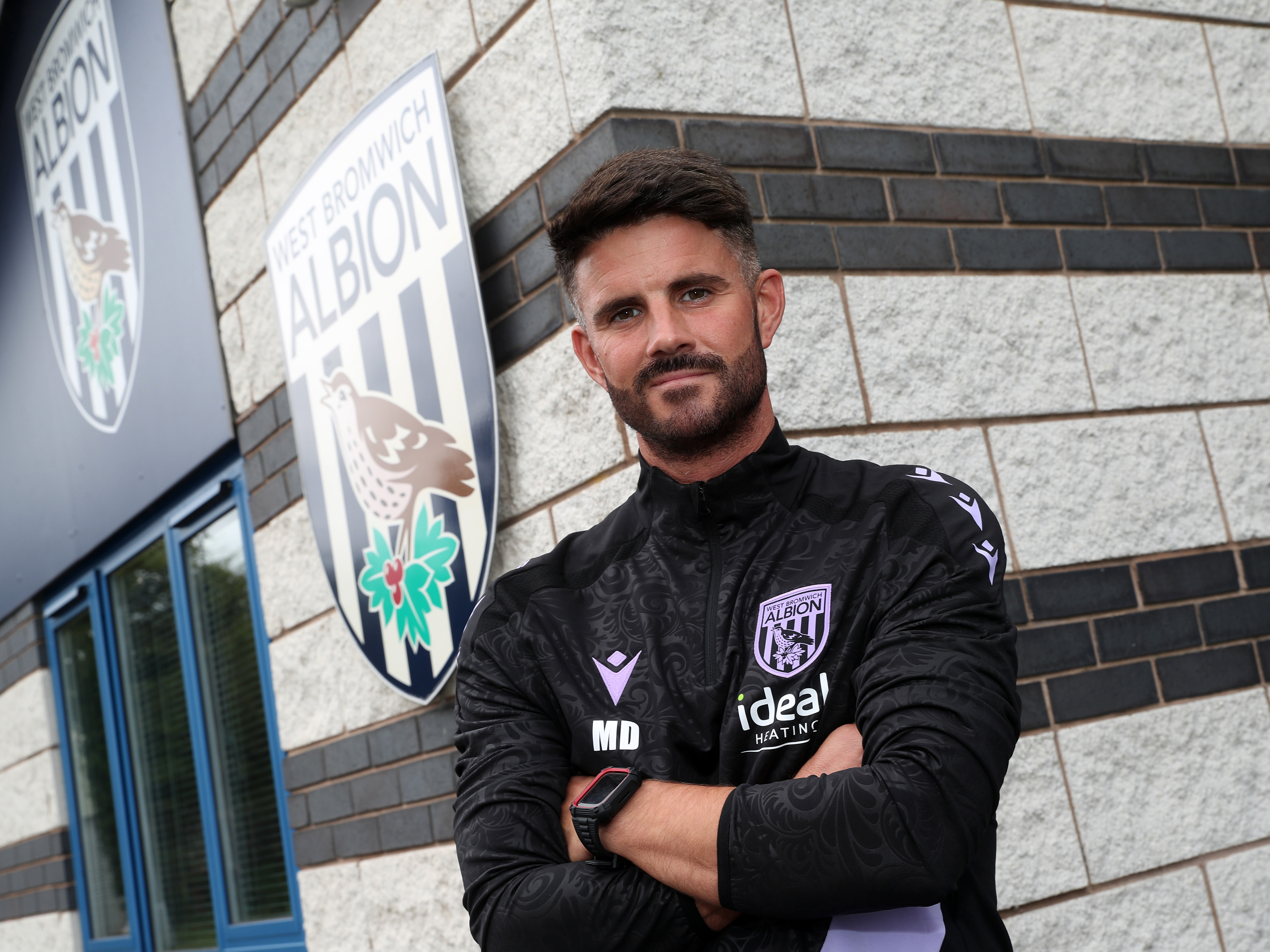 Martin Drury smiling at the camera outside the front of the training ground 