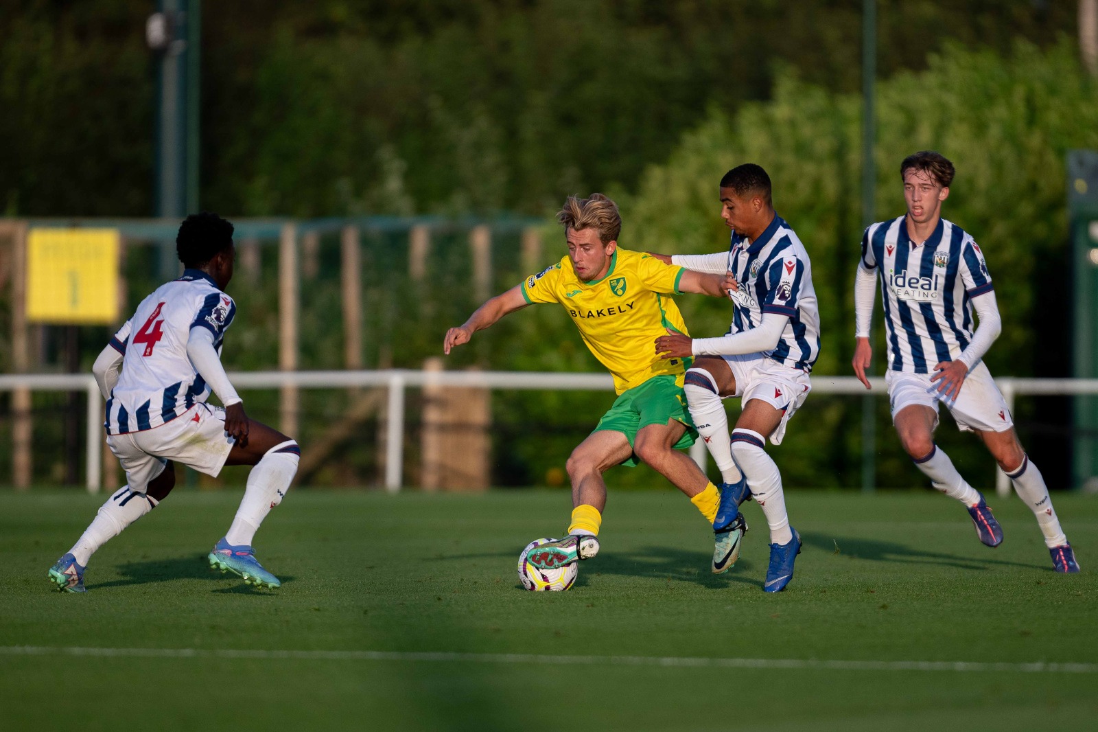 Three Albion players try and get the ball back off a Norwich PL2 player 