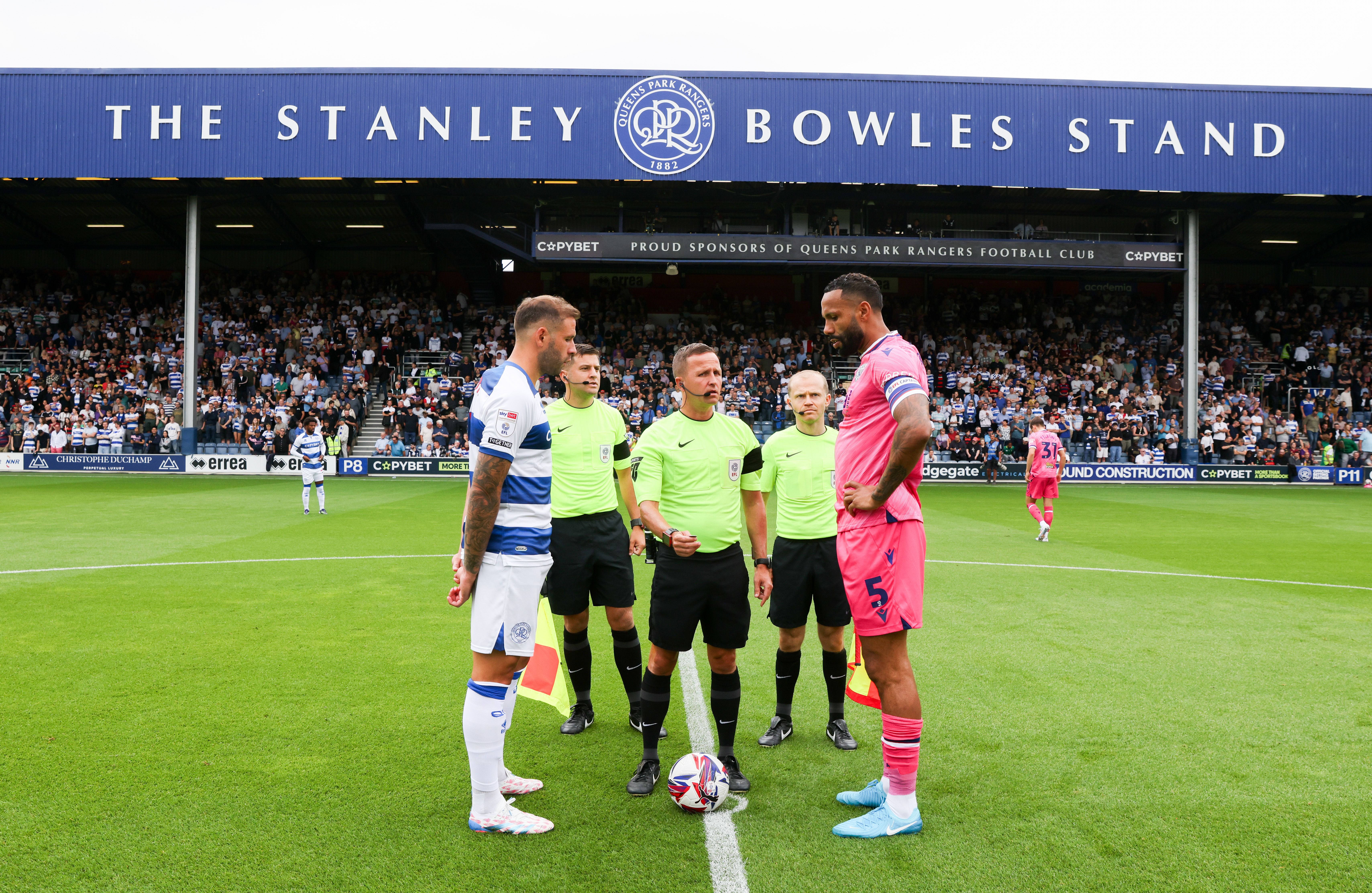 Kyle Bartley and the QPR captain line up for the coin toss on the halfway line with the officials 